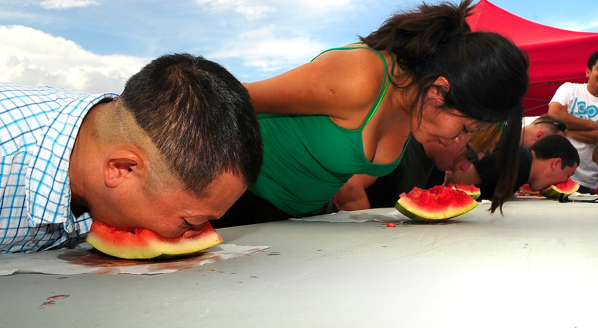 1st Lieutenant Thomas Truong of the 846th Test Squadron (left) competes with with Fabiola Sanchez (center) and other contestants in the watermellon eating contest during the Fourth of July celebrations at Holloman Air Force Base, N.M. (U.S. Air Force Photo/Tech. Sgt. Chris Flahive)