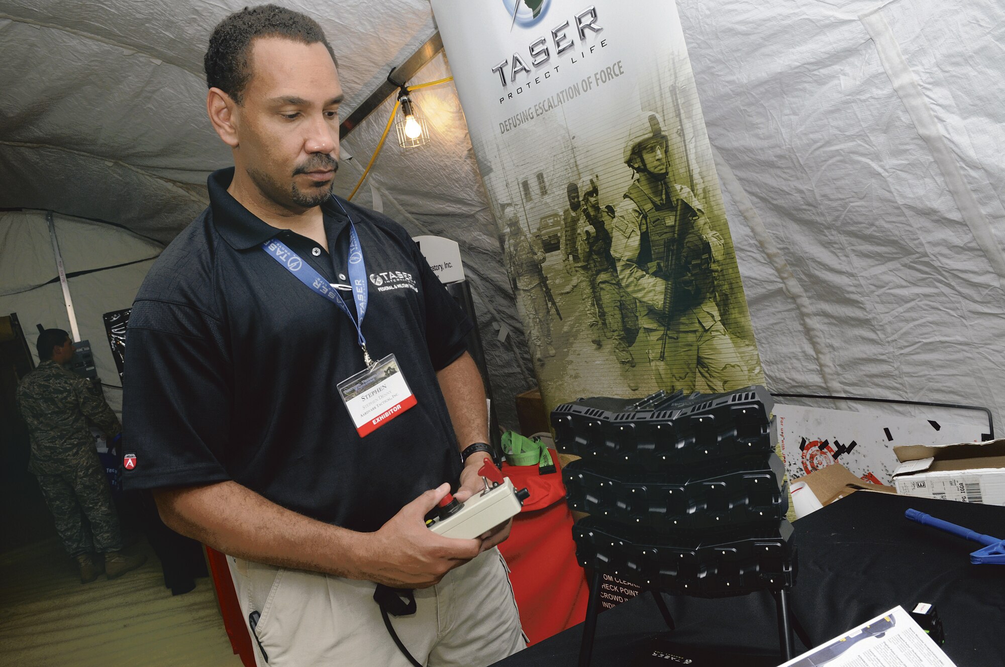 Steve Denny demostrates some tasers for his company, Taser Protect Life, at the Tactical Technology Showcase hosted by the 5th Combat Communications group July1. U. S. Air Force photo by Sue Sapp