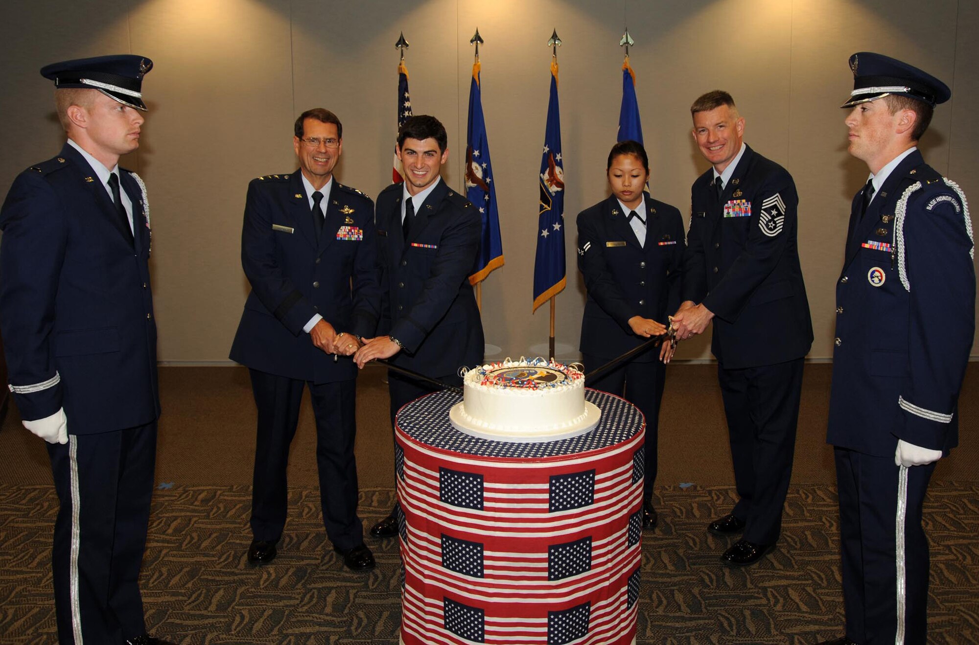 Lt. Gen. Tom Sheridan, Space and Missile System Center commander, presided over the ceremony commemorating SMC’s 55th Anniversary, July 1.   LAAFB’s youngest officer and airman Lt. Alex Menas and Airman 1st Class Larissa Lilie, assisted by Chief Master Sgt. Stephen Ludwig, SMC command chief, and the general, had the honor of cutting the ceremonial cake. Honor guard members Lt. Josh Duckett and Lt. Kevin Williams also are pictured. (Photo by Lou Hernandez)