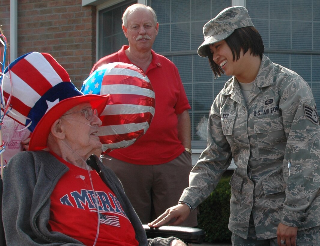 NILES, Ohio -- U.S. Air Force Reservist Staff Sgt. Jessica M. Walker, a personnel specialist assigned to the 910th Mission Support Group at the Youngstown Air Reserve Station, shares stories and laughs with a veteran at the Autumn Hills nursing home here July 2.  Autumn Hills residents more than 100 years old, referred to as centurians by the nursing home, participated in a wheelchair parade to honor veterans of World War II and the Korean War.  U.S. Air Force photo by Maj. Brent Davis