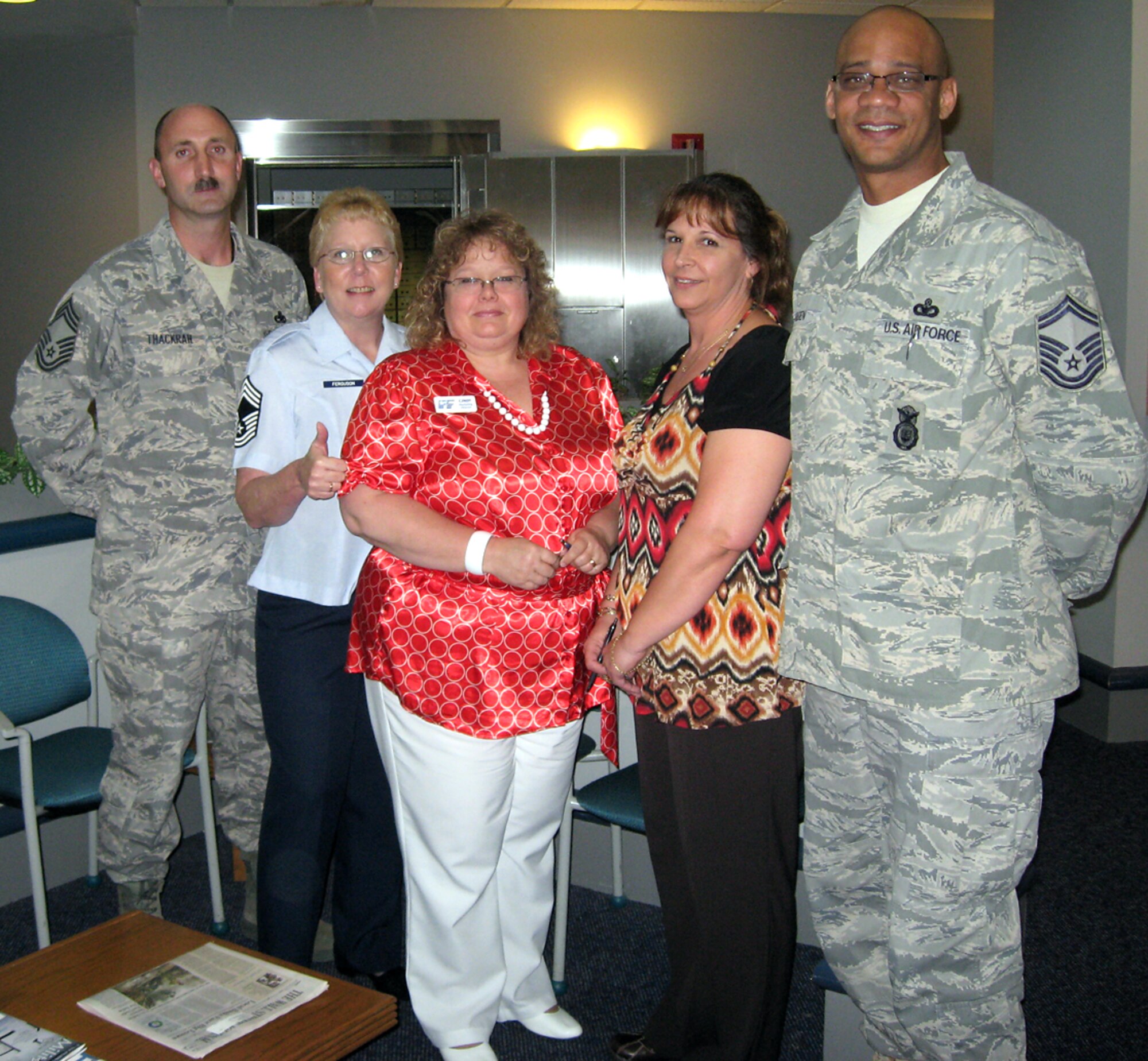 MCCONNELL AIR FORCE BASE, Kan. -- Chief Master Sgt. Tom Thackrah, 22nd Aircraft Maintenance Squadron superintendent, Chief Master Sgt. Susan Ferguson, 22nd Force Support Squadron superintendent, Cindy Pawlak Freedom First Credit Union marketing director, Irene Post, Freedom First Credit Union lending supervisor, and Chief Master Sgt. Michael Bolden, 22nd Security Forces Squadron superintendent, pose for a picture July 2.  The chiefs presented Ms. Pawlak and Ms. Post with coins for their work and contributions to McConnell’s Airmen. (Photo by Chief Master Sgt. Susan Ferguson)
