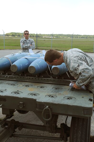 Staff Sgt. Cory Watson, 4th Equipment Maintenance Squadron quality assurance inspector, evaluates Airman 1st Class Patric Senchuk, 4th Aircraft Maintenance Squadron flightline support technician, during a munitions inspection on the flightline at Seymour Johnson Air Force Base N.C., June, 30, 2009. During the inspection Airman Senchuk checked for foreign object debris, munitions configuration and explosives security to ensure base safety. (U.S. Air Force photo by Airman 1st Class Whitney S. Lambert) 