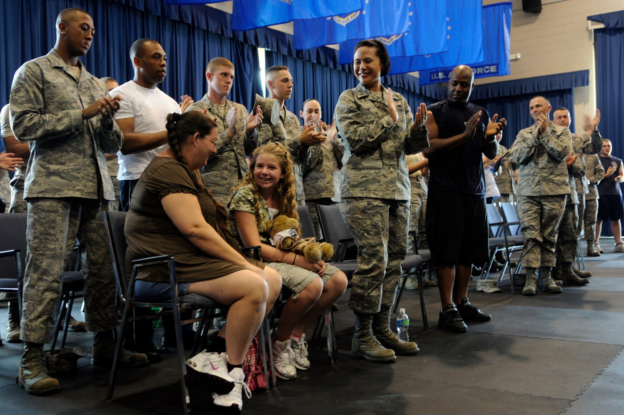 Bailey Reese, founder and president of the non-profit organization, Hero Hugs, and her mother, Diana, receive a standing ovation from members of both the United States Air Force Honor Guard and the 11th Wing after being introduced at the Drill Team’s evaluations July 7 on Bolling Air Force Base, D.C. Bailey first met the Drill Team at Dobbins Air Reserve Base, Ga., during one of the team’s performances and was invited to visit the Drill team back in D.C. (U.S. Air Force photo by Staff Sgt. Dan DeCook)