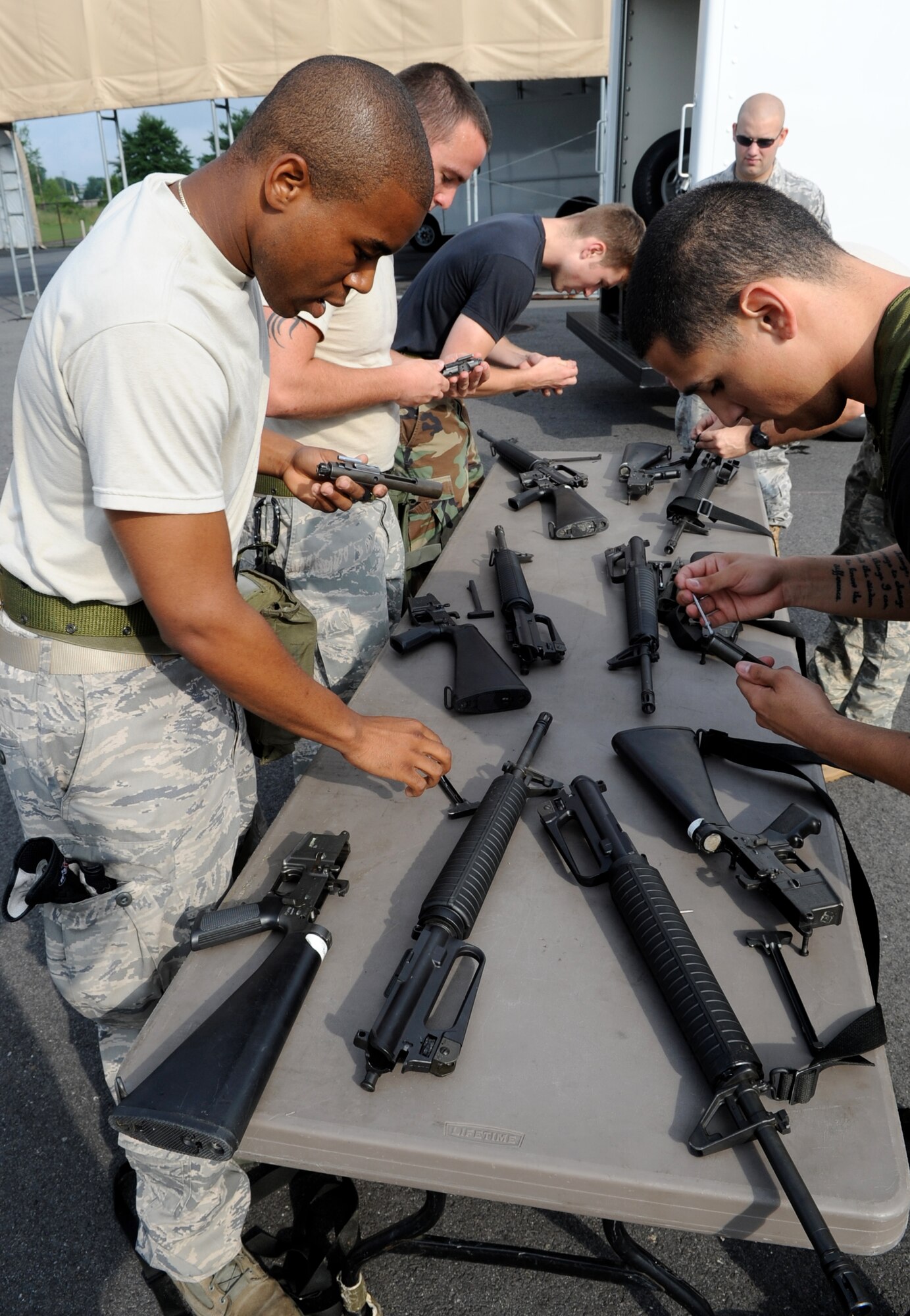 The 305th Aerial Port Squadron Rodeo Team of five Airmen reassembles and function-checks M-16 rifles as one of their tasks during their practice obstacle run. Everything is timed during the course, which the team runs once a week - always striving for improvement over the last run. (U.S. Air Force photo/Wayne Russell)
