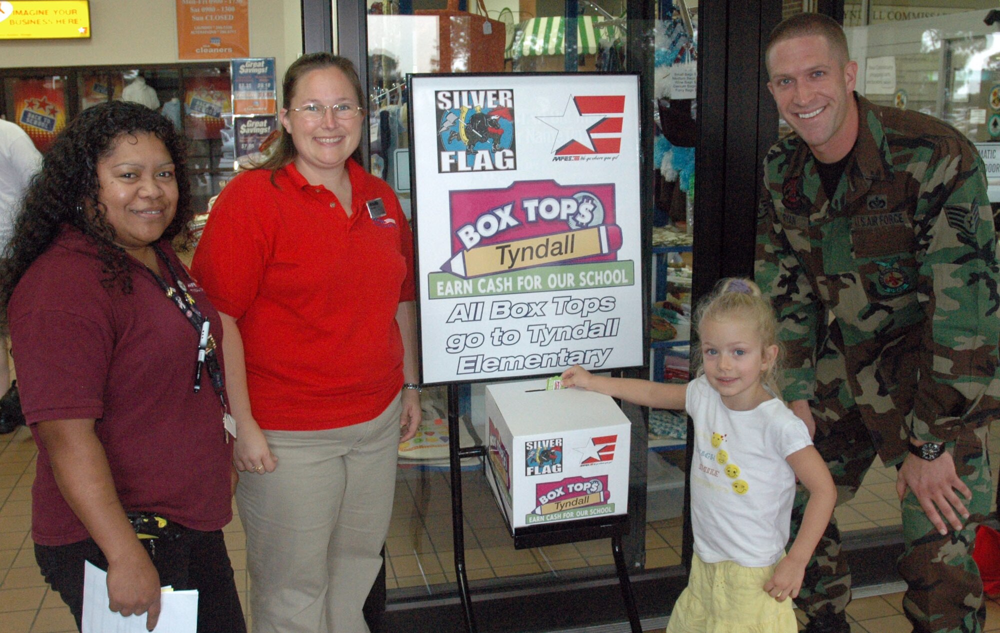 Staff Sgt. Thomas T. Ryan, a Fire Contingency Instructor for Det. 1 823rd Red Horse Squadron,  his daughter Caitlyn A. Ryan,  and AAFES team together to raise money for Tyndall Elementary through the Box Tops for Education project.  Each box top earns the school ten cents toward supplies. The box tops can be found on an array of products, from cereal to trash bags. The drop box can be found right inside the entrance of the BX. (U.S. photo by/Airman 1st Class Rachelle Elsea)