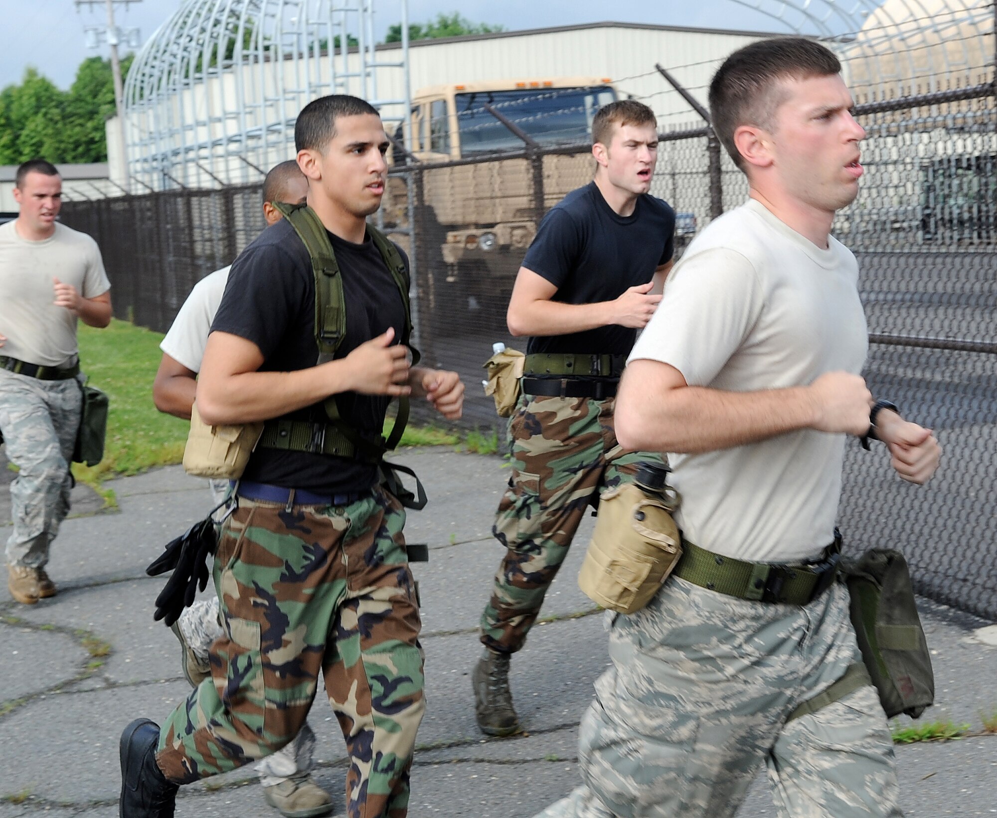 All throughout the morning while running the obstacle course, the 305th Aerial Port Squadron Rodeo Team demonstrates the mentality that no man is left behind. The run is started and finished together with chemical mask, work gloves and water. Even if some finish the run before others, the next task cannot be started until the whole team finishes the lap. (U.S. Air Force photo/Wayne Russell)
