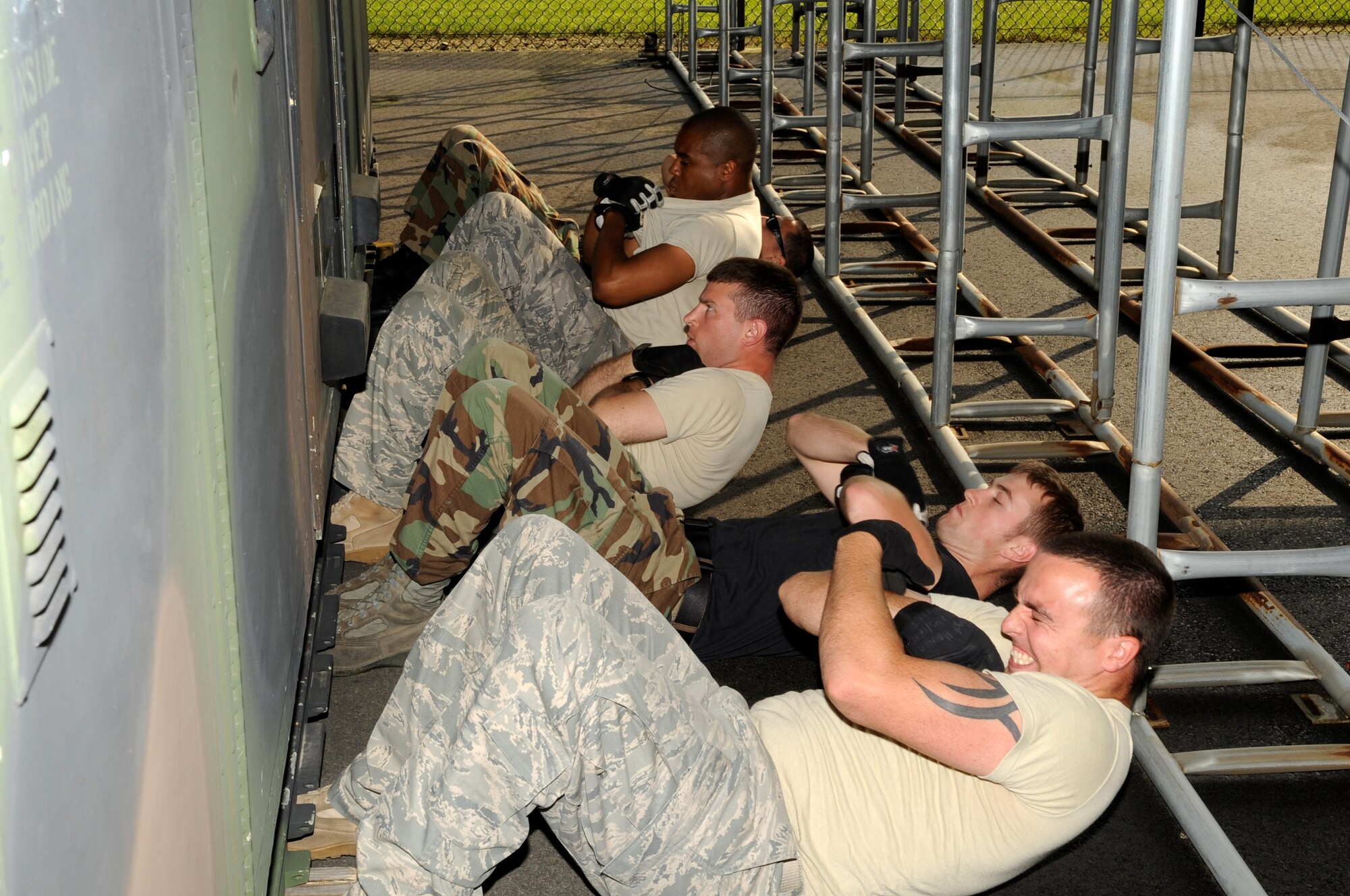 In preparation for the upcoming Rodeo Competition, the 305th Aerial Port Squadron Rodeo Team (front to back: Staff Sgt. Timothy Hackett, Airman 1st Class Travis Rovelto, Staff Sgt. Jonathan Corwine, Airman 1st Class Andrew Richardson and Airman 1st Class Marcus Rodriguez) starts the morning of July 2 with an obstacle course. The first challenge: Do as many crunches as possible in a 2-minute time limit. (U.S. Air Force photo/Wayne Russell)
