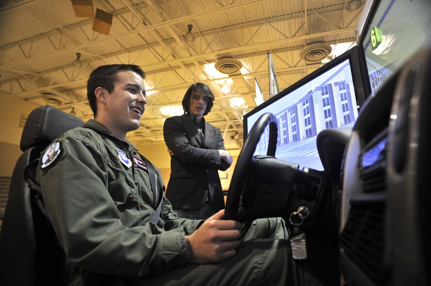 2nd Lt. Mike Anchustegui, 12th Missile Squadron missile combat crew member, operates an impaired driving simulator as Brian Beldyga describes how alcohol impairs a person's ability to safely operate a motor vehicle. (U.S. Air Force photo/John Turner)