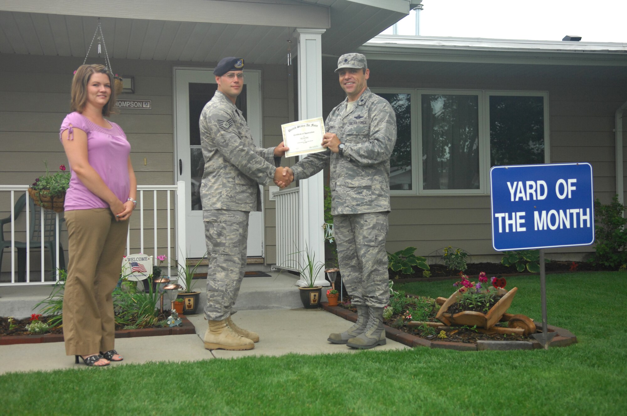 MINOT AIR FORCE BASE, N.D. -- (From right) Lt. Col. George McDowell, 5th Mission Support Group deputy commander, presents Staff Sgt. Vernon Thompson, 791st Missile Security Forces Squadron and his spouse Lindsay, with a certificate here July 7. The Thompson's meticulously maintained residence earned them yard of the month for June. The Thompsons received a $100.00 saving bond from the Minot Chapter of the Air Force Association, a $10.00 gift card from AAFES, and $15.00 in Darby Dollars to spend in 5th Force Support Squadron facilities. (U.S. Air Force photo by Senior Airman Wesley Wright)