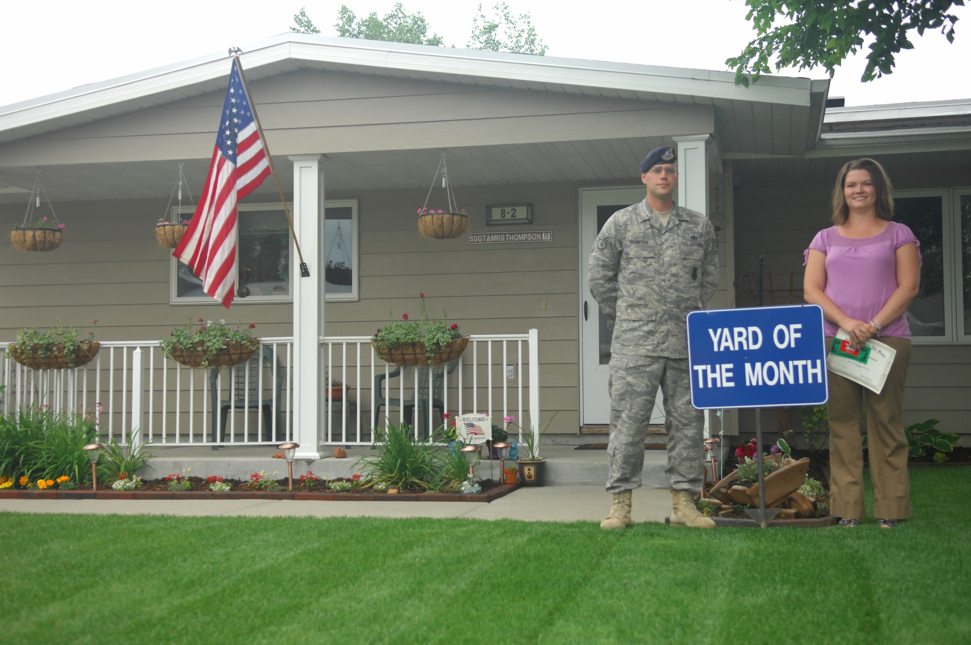 MINOT AIR FORCE BASE, N.D. -- Staff Sgt. Vernon Thompson, 791st Missile Security Forces Squadron and his spouse Lindsay, pose in front of their residence here July 7. Their meticulously maintained residence earned them yard of the month for June. The Thompsons received a $100.00 saving bond from the Minot Chapter of the Air Force Association, a $10.00 gift card from AAFES, and $15.00 in Darby Dollars to spend in 5th Force Support Squadron facilities. (U.S. Air Force photo by Senior Airman Wesley Wright)