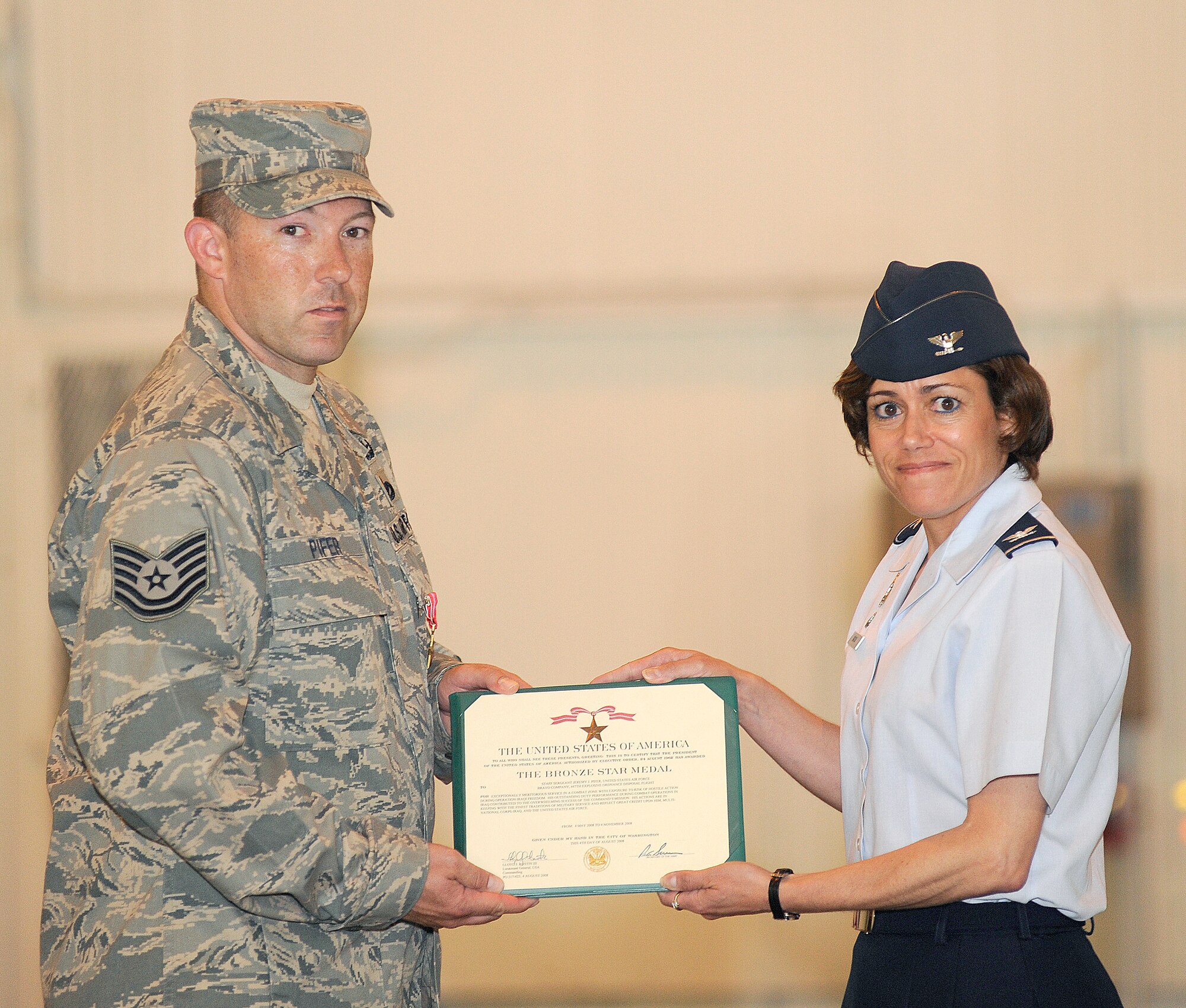 Col. Gina Grosso, 87th Air Base Wing commander, presents a Bronze Star to Staff Sgt. Jeremy J. Pifer, 87th Civil Engineer Squadron, July 6 here. Sergeant Pifer served in Iraq as the explosive ordnance disposal team leader from May 4, 2008, to Nov. 4, 2008, during Operation Iraqi Freedom. While conducting a route clearance mission, an engineer vehicle in his convoy was struck by an explosively-formed projectile, which wounded three Soldiers inside and destroyed the vehicle. He cleared the scene of explosive hazards and helped triage the wounded and evacuate them to safety. (U.S. Air Force photo/Carlos Cintron)