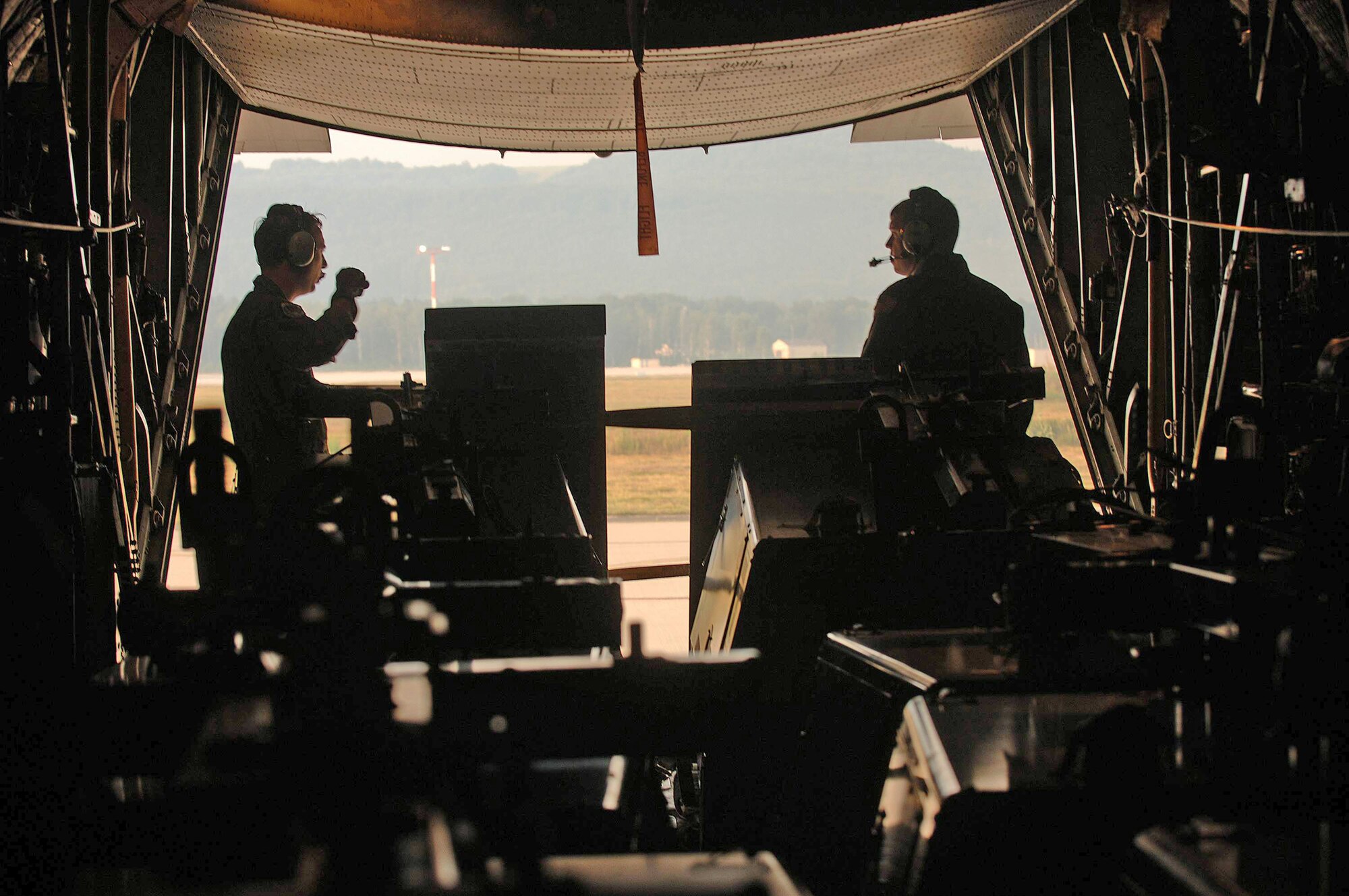 Staff Sgt. Samuel Yearber and Senior Airman Glenn Scott prepare for takeoff on a C-130 Hercules to transport 10 portable light carts to Moscow's Vnukovo International Airport in preparation for President Barack Obama's scheduled visit to Russia July 3 from Ramstein Air Base, Germany. Sergeant Yearber and Airman Scott are C-130 loadmasters. (Defense Department photo/Master Sgt. Scott Wagers)