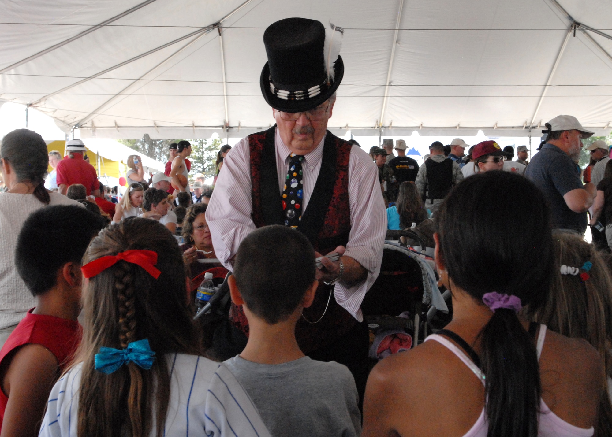 BUCKLEY AIR FORCE BASE, Colo. -- Robert "Ned" Balski performs a magic trick for children at Freedom Fest here, July 1.  The magic was just part of the entertainment provided for children along with great food, raffle prize giveaways and live music.  (U.S. Air Force photo by Tech. Sgt. Shirley Henderson)