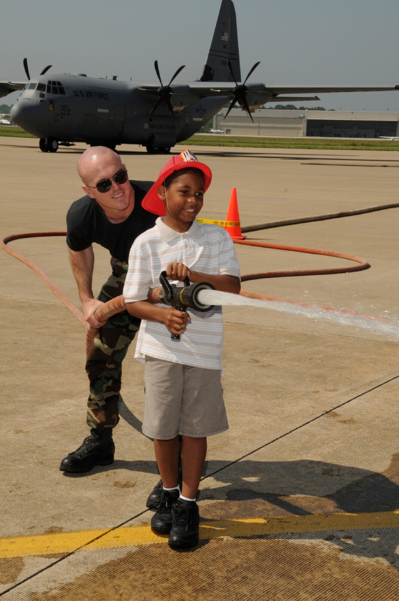 Jalen Evans takes control of a fire hose under the close supervision of SSgt. Michael Dowling at Family Day 2009.  (U.S. Air Force photo by TSgt. Chris Schepers (released), Official Photo By: TSgt. Chris Schepers, 175th Public Affairs, WARFIELD AIR NATIONAL GUARD BASE, Maryland , United States 3
