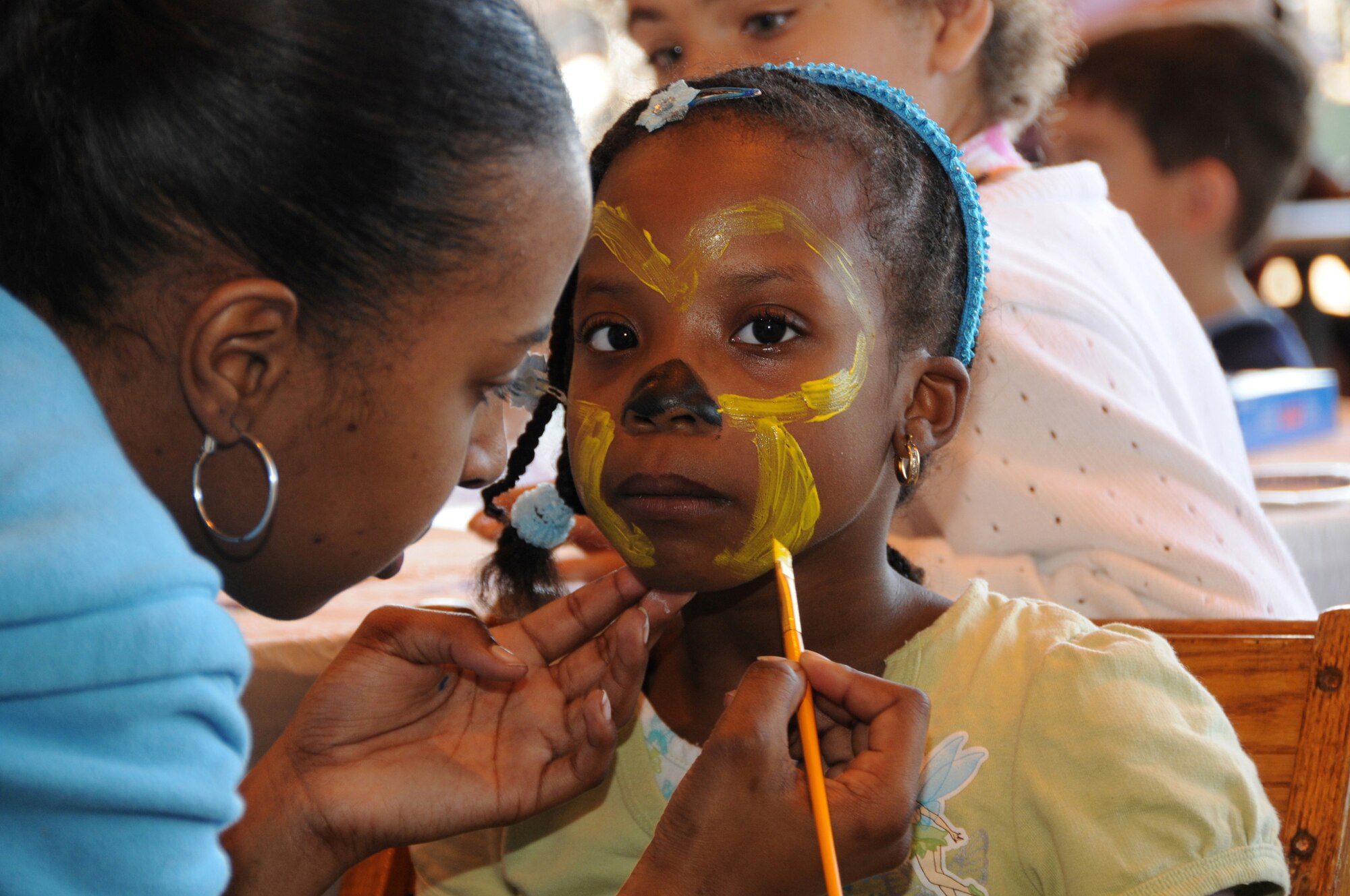 Kevita Bryant sits patiently as she gets her face painted by a volunteer from the Family Readiness Group during Family Day 2009.
 (U.S. Air Force photo by TSgt. Chris Schepers (released), 175th Public Affairs, WARFIELD AIR NATIONAL GUARD BASE, Maryland , United States 

