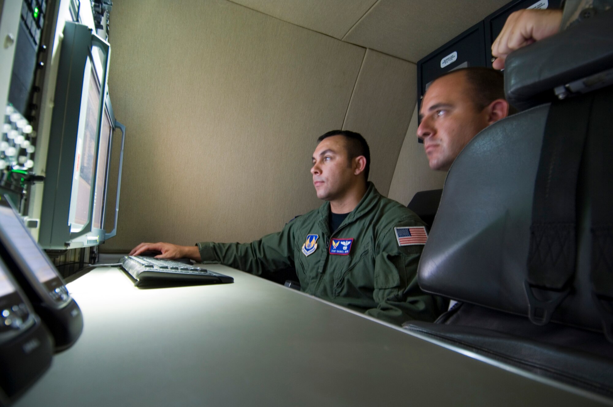 HANSCOM AIR FORCE BASE, Mass. – Staff Sgt. Daniel A Wowk (left), a communications systems operator from the 412th Flight Test Squadron out of Edwards AFB, Calif., describes features of Test Tanker II to 2nd Lt. Dan Elias of the SCP Program office here June 30.  The Hanscom AFB-based program team will use Test Tanker II to test standardized command, control and communications (C3) equipment that will be incorporated on a special fleet of aircraft used to transport senior U.S. officials.  (USAF Photo by Rick Berry)