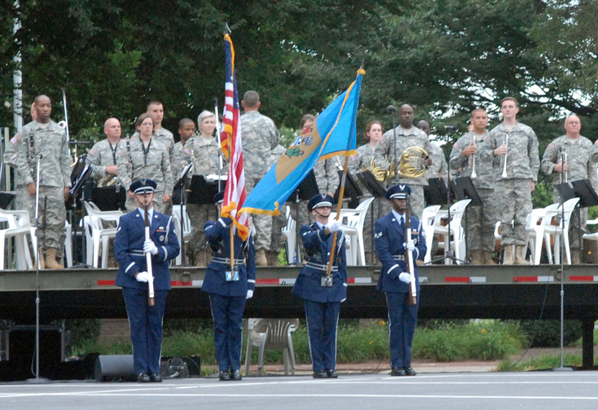 A Dover Air Force Base honor guard team posts the colors and salutes as a member of the 287th Army Band from the Delaware National Guard sings the national anthem. After the colors were posted, the band played patriotic music. The evening ended with a firework display. (U.S. Air Force photo/Tech. Sgt. Kevin Wallace)