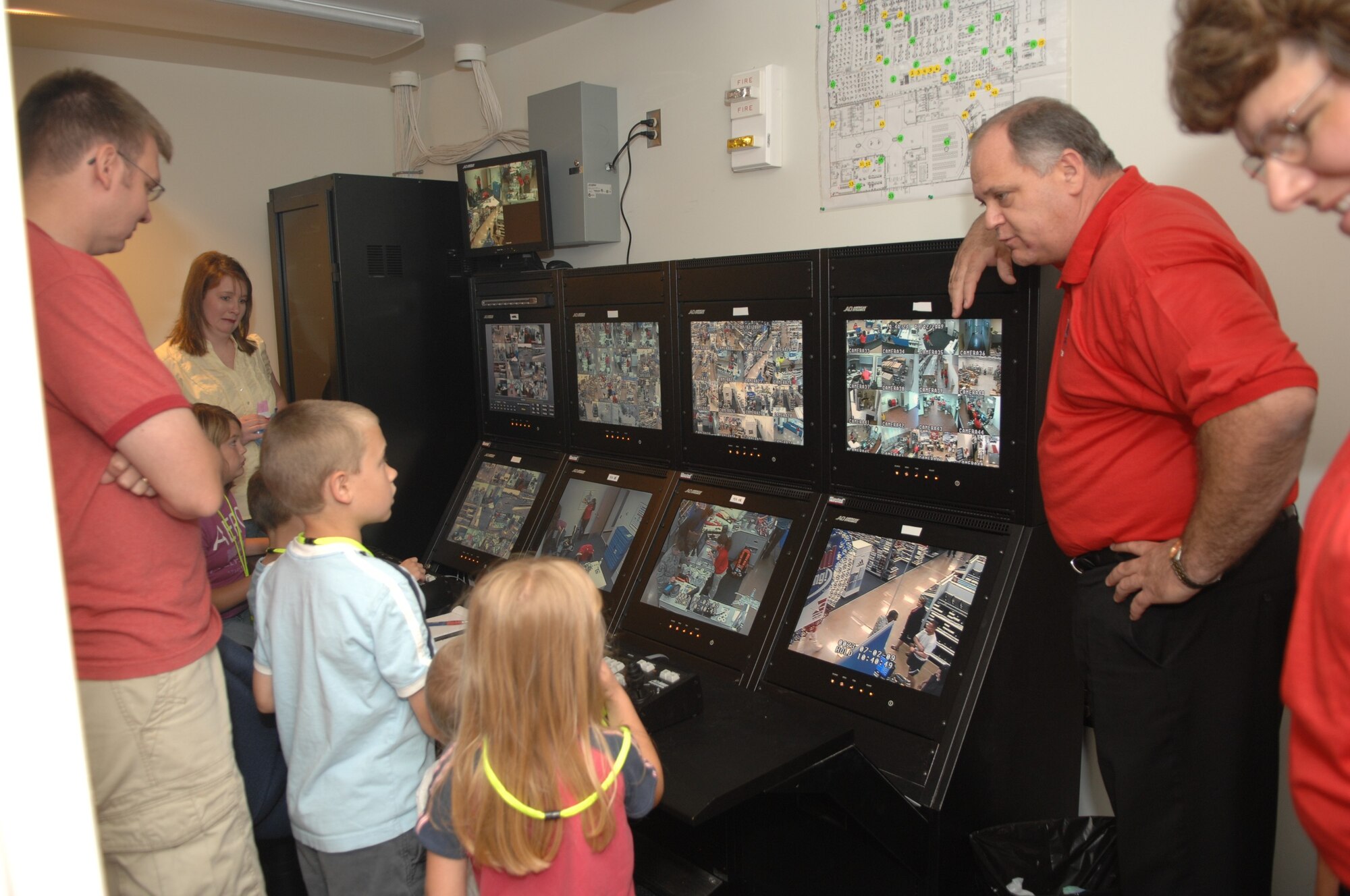 MINOT AIR FORCE BASE, ND -- Loss Prevention Managers shows security camera system to some of the children and their parents attending the ribbon cutting ceremony at the grand opening of the new Base Exchange facility here July 2. This new facility is 86,000 square feet and state-of-the-art in every way, from better lighting to vastly improved store layouts.  (U.S. Air Force photo by Staff Sgt. Angel Gallardo)