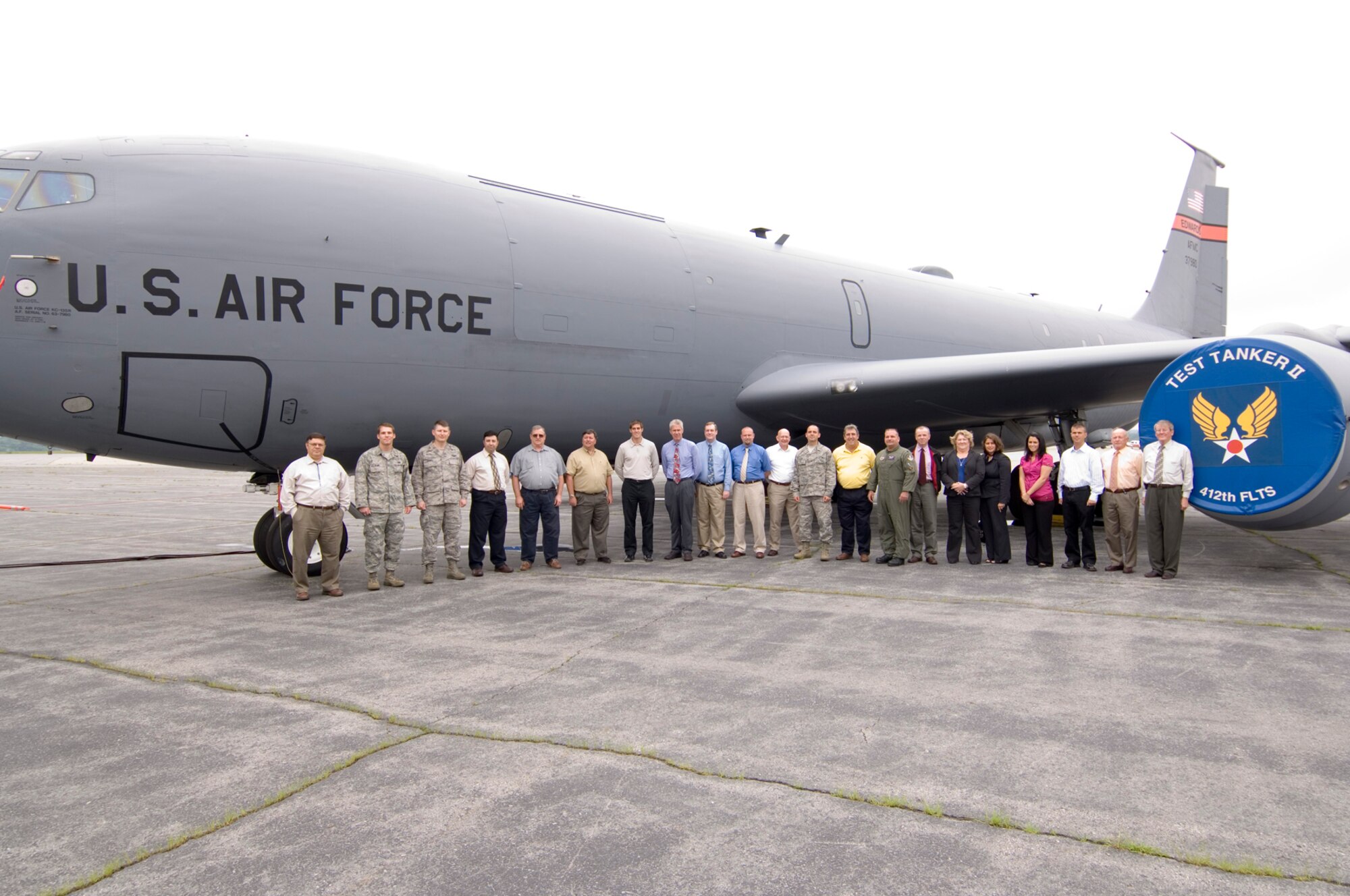 HANSCOM AIR FORCE BASE, Mass. -- Personnel from the Senior Leadership C3 System - Airborne Communications Program office line up in front of a modified KC-135 known as Test Tanker II June 30.  The program team will use Test Tanker II to test standardized command, control and communications (C3) equipment that will be incorporated on a special fleet of aircraft used to transport senior U.S. officials.  (USAF Photo by Rick Berry)