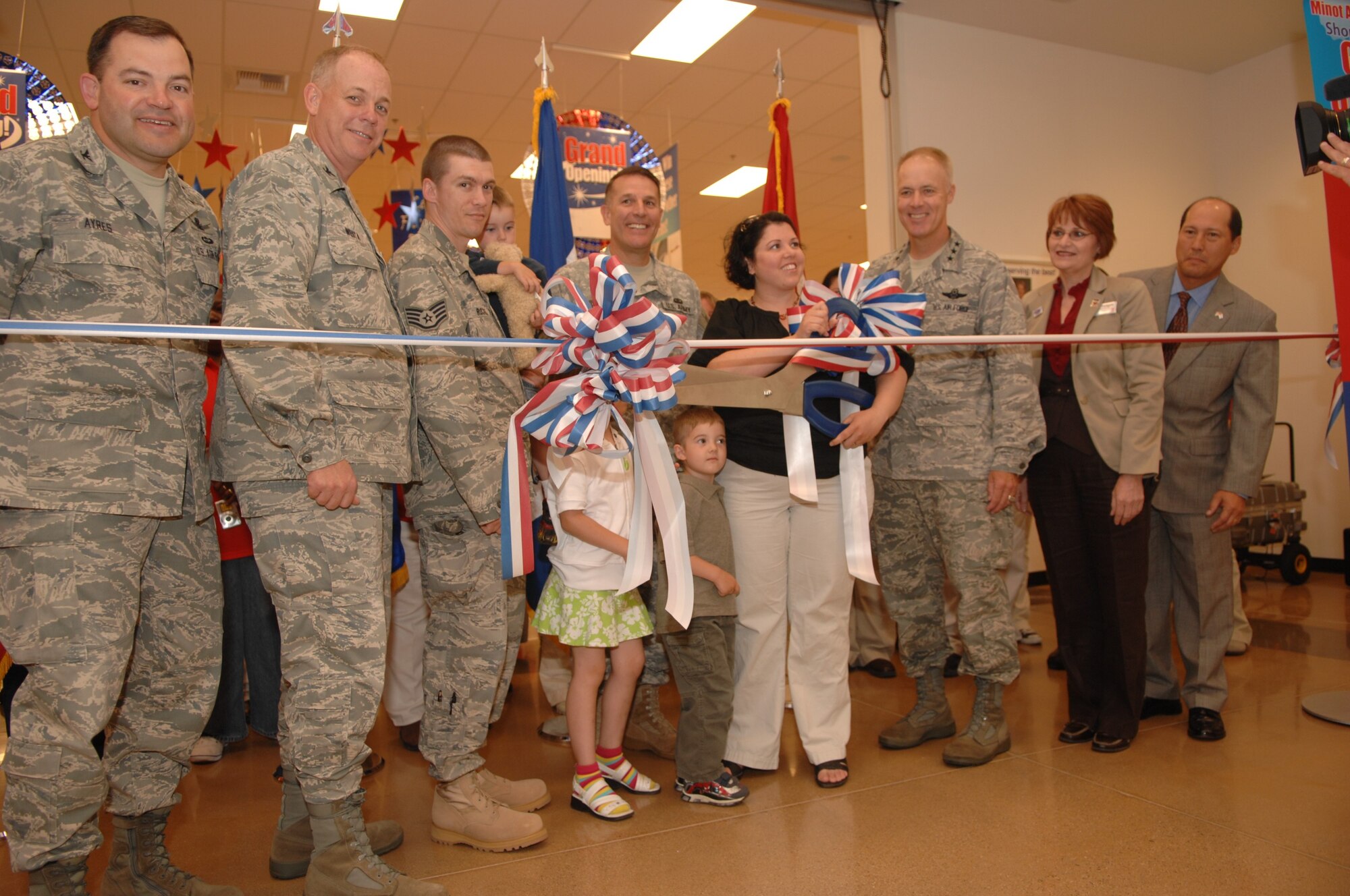 MINOT AIR FORCE BASE, ND -- Leaders from the 91st Missile Wing and 5th Bomb Wing join Staff Sgt. Lucian Rockwell, 5th Aircraft Maintenance Squadron, and his wife Jennifer during ribbon cutting ceremony at the grand opening of the new Base Exchange facility here July 2. The new facility is 86,000 square feet and state-of-the-art in every way, from better lighting to vastly improved store layouts. 2009 was a year that brought progress and a renewed emphasis on safe, secure and reliable nuclear operations. The 91st Missile Wing transitioned to Air Force Global Strike Command with the 5th Bomb Wing scheduled to follow suit in 2010. (U.S. Air Force photo by Staff Sgt. Angel Gallardo)