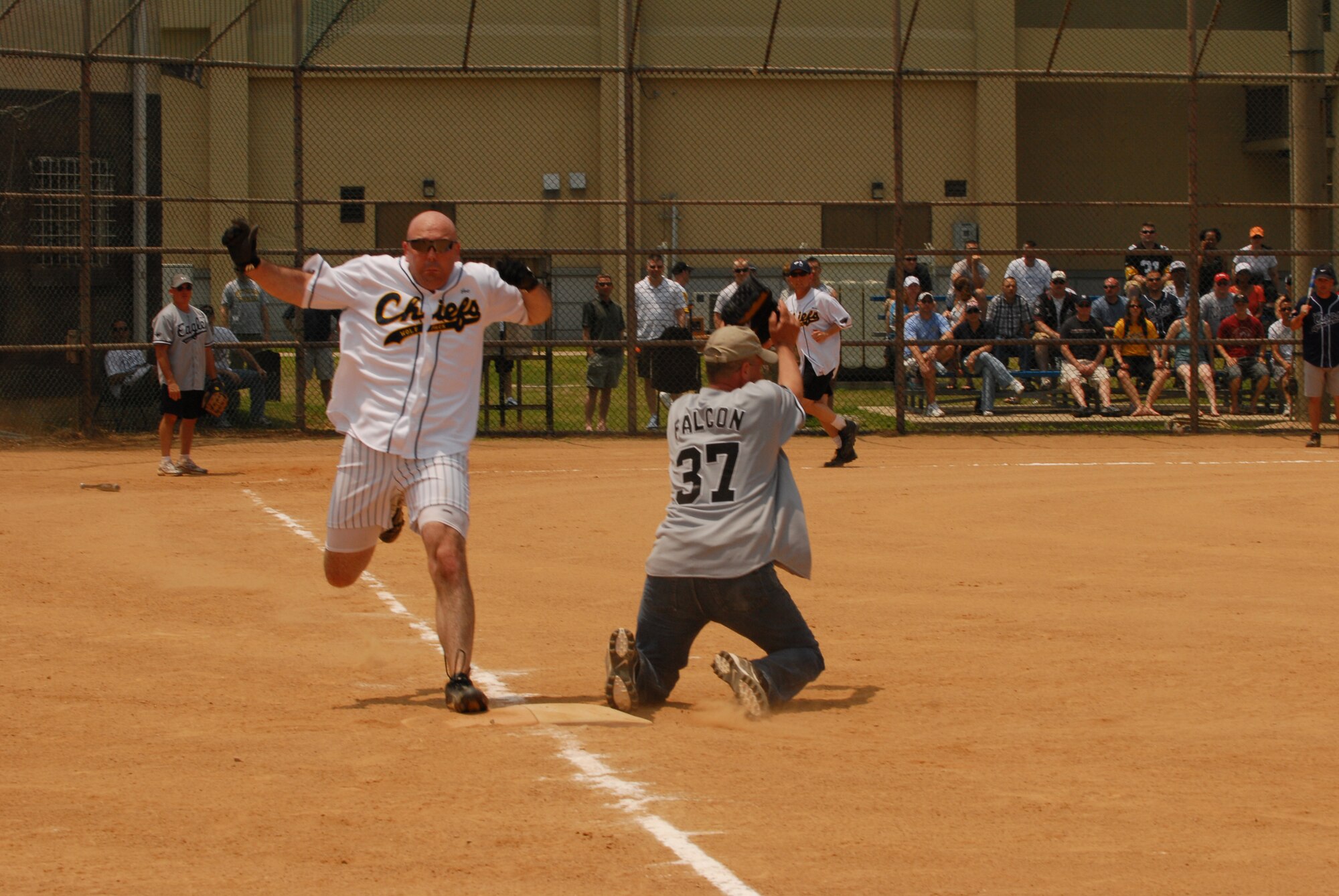 Chief Master Sgt. Joseph "Wolf Chief" Riff, 8th Fighter Wing command chief, is called out at first base on a grounder caught by Col. Patrick "Falcon" Clements, 8th Mission Support Group commander, during the annual Chiefs and Eagles matchup at Kunsan Air Base, Republic of Korea, July 4. The Chiefs triumphed over the Eagles 13 - 1. (U.S. Air Force Photo by Staff Sgt. Patrice Clarke)