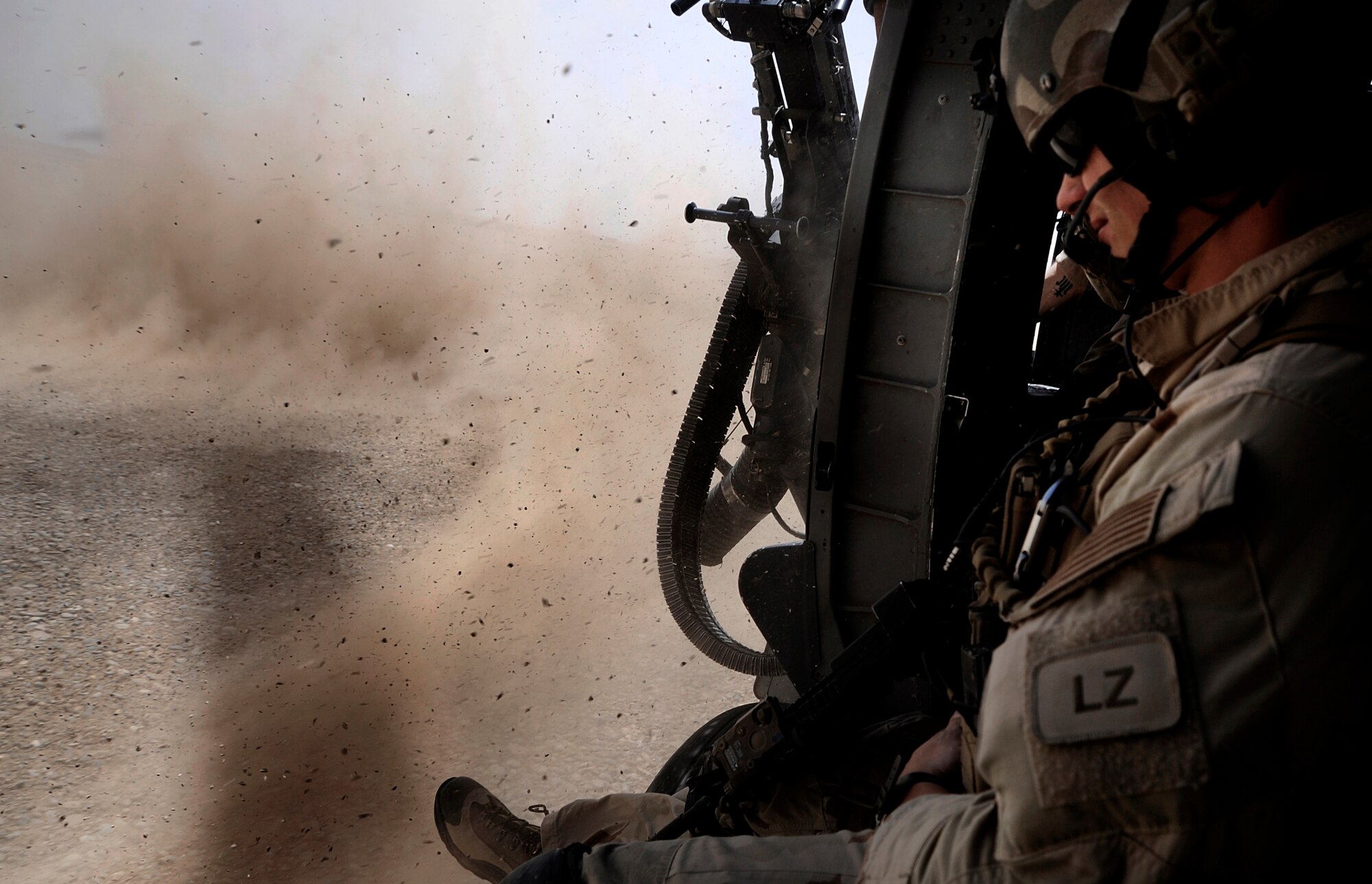 As dust kicks up from the rotor wash of an HH-60G Pave Hawk, Senior Airman Clint Lentz, pararescueman with the 129th Expeditionary Rescue Squadron, prepares for the landing June 26, 2009, Hemland Province, Afghanistan. Airman Lentz and the rest of the crew are responding to a Medevac request to aid personnel conducting combat operations further down range.  (U.S. Air Force photo by Staff Sgt. Shawn Weismiller)