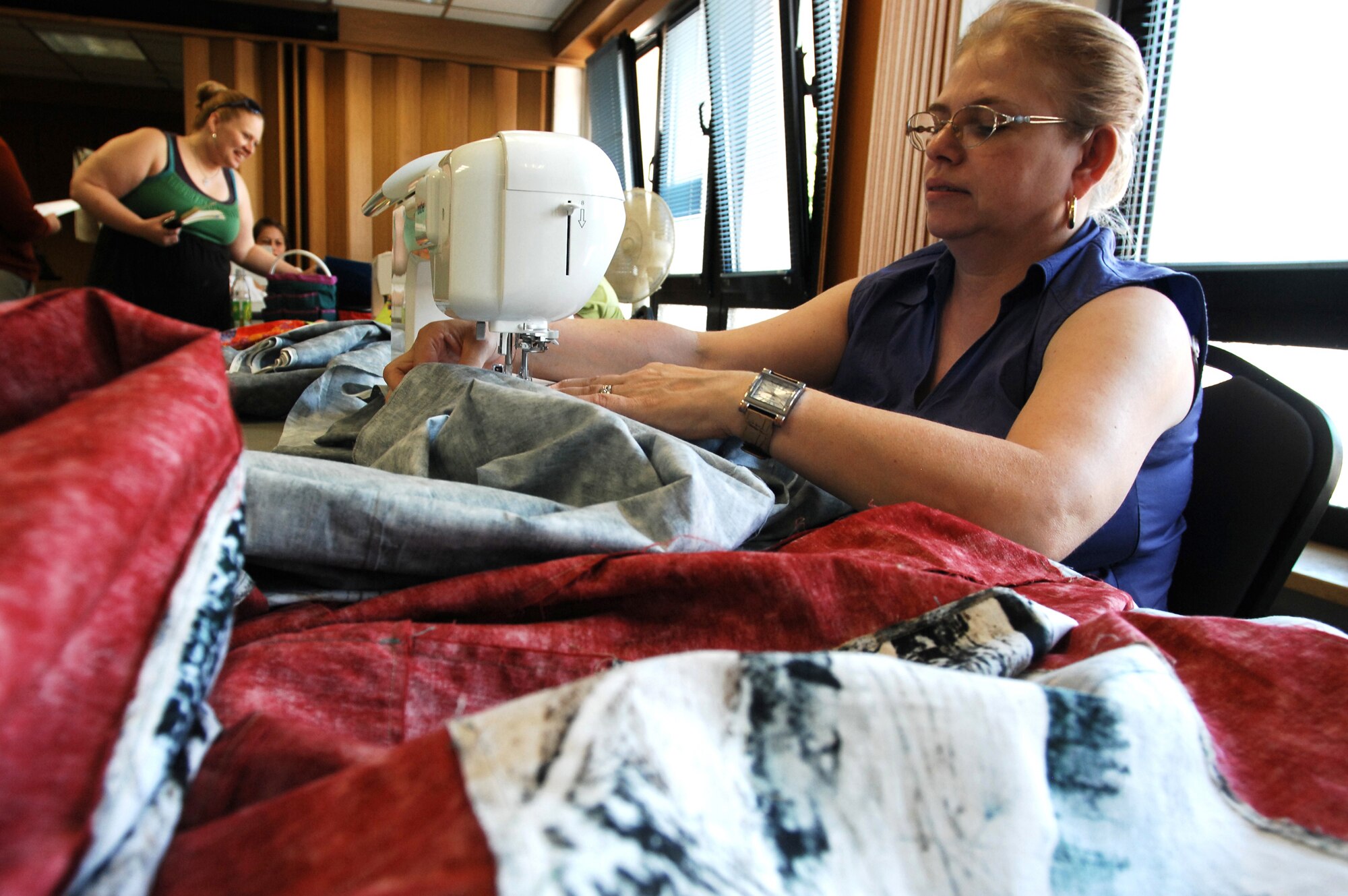 Ms. Mary Schmidt, member of the Rheinland-Pfalz Quilt Guild sews together fabric for a quilt cover on June 26, 2009, Ramstein Air Base, Germany. The quilt guild is a non-profit organization that gets together weekly to fellowship and sew. They also create Quilts of Valor for wounded warriors and Baby Love Quilts for babies in the neonatal intensive care unit at Landstuhl Regional Medical Center.   (U.S. Air Force photo by Tech.  Sgt. Chenzira Mallory)