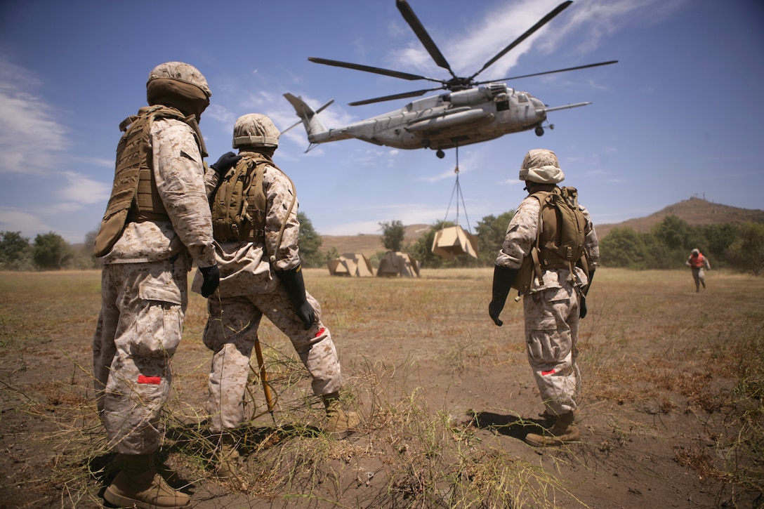 CAMP PENDLETON, Calif. (July 8, 2009) - U.S. Marines with Helicopter Support Team(HST), Landing Support Company (LS Co.), Combat Logistics Regiment 17 (CLR-17), 1st Marine Logistics Group (1st MLG), watch as the 12,000 pound target they attached is lifted by a CH-53E from Marine Heavy Helicopter Squadron 465 (HMM-465), Marine Aircraft Group 16 (MAG-16), 3rd Marine Aircraft Wing (3rd MAW), Marine Corps Air Station (MCAS) Miramar, Calif.  The targets will be used for live fire training on Camp Pendleton. (U.S. Marine Corps photo by Sgt. Brian Lautenslager)