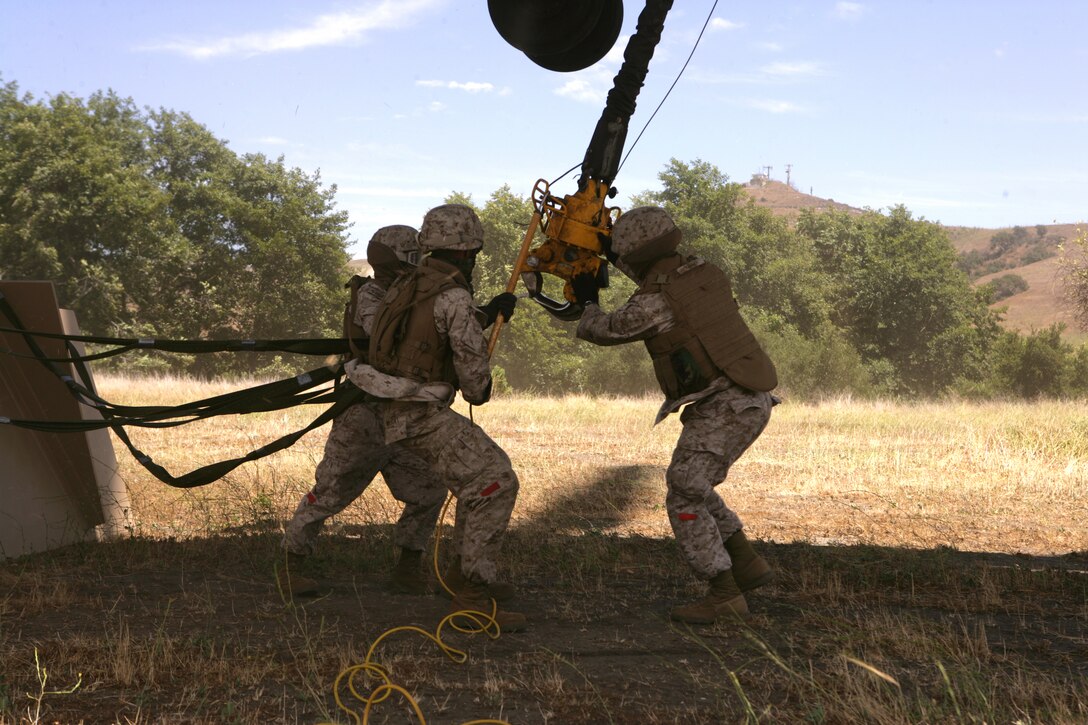 U.S. Marines with Helicopter Support Team (HST), Landing Support Company (LS Co.), Combat Logistics Regiment 17 (CLR-17), 1st Marine Logistics Group (1st MLG), attach a 12,000 pound metal target to a CH-53E helicopter, with Marine Heavy Helicopter Squadron 465 (HMM-465), Marine Aircraft Group 16 (MAG-16), 3rd Marine Aircraft Wing (3rd MAW), Marine Corps Air Station (MCAS) Miramar, Calif.