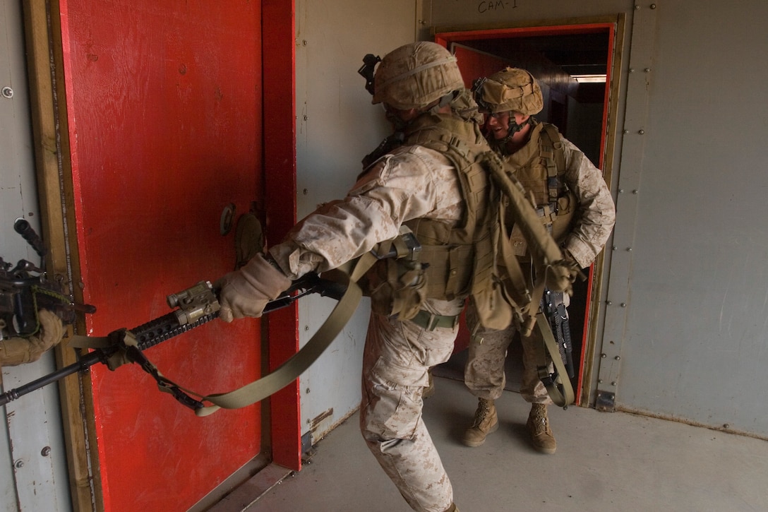 Marines kick through a lock door to gain entry into a room at the Range 1 "shoot house" July 8.
