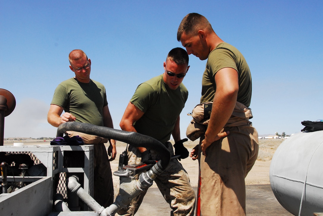 Emergency aircraft recovery crewmen Lance Cpl. Tony Eck, left, Lance Cpl. Nick Gohl, and Lance Cpl. Josh Kidwell tighten a plug on the engine of one of four sets of arresting gear on the flight line at the Marine Corps Air Station in Yuma, Ariz., July 8, 2009. The recovery crew repaired a set of gear that was out of operation for more than two years. The device uses a heavy steel cable and heavy nylon tapes to rapidly decelerate landing aircraft in an emergency, much like the arresting gear on an aircraft carrier.