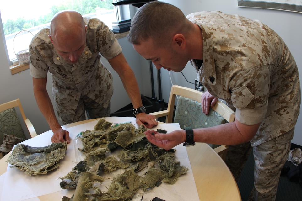 For the first time in more than five years, Sgt. Mark Dean, one of Medal of Honor recipient Cpl. Jason Dunham’s close friends, and Maj. Trent A. Gibson, Dunham’s former company commander, carefully sort out the pieces of the Kevlar helmet Dunham used to help absorb the blast of a grenade in the streets of Iraq in 2004. The pair delivered the helmet to the National Museum of the Marine Corps July 9 to be displayed in the coming years.
