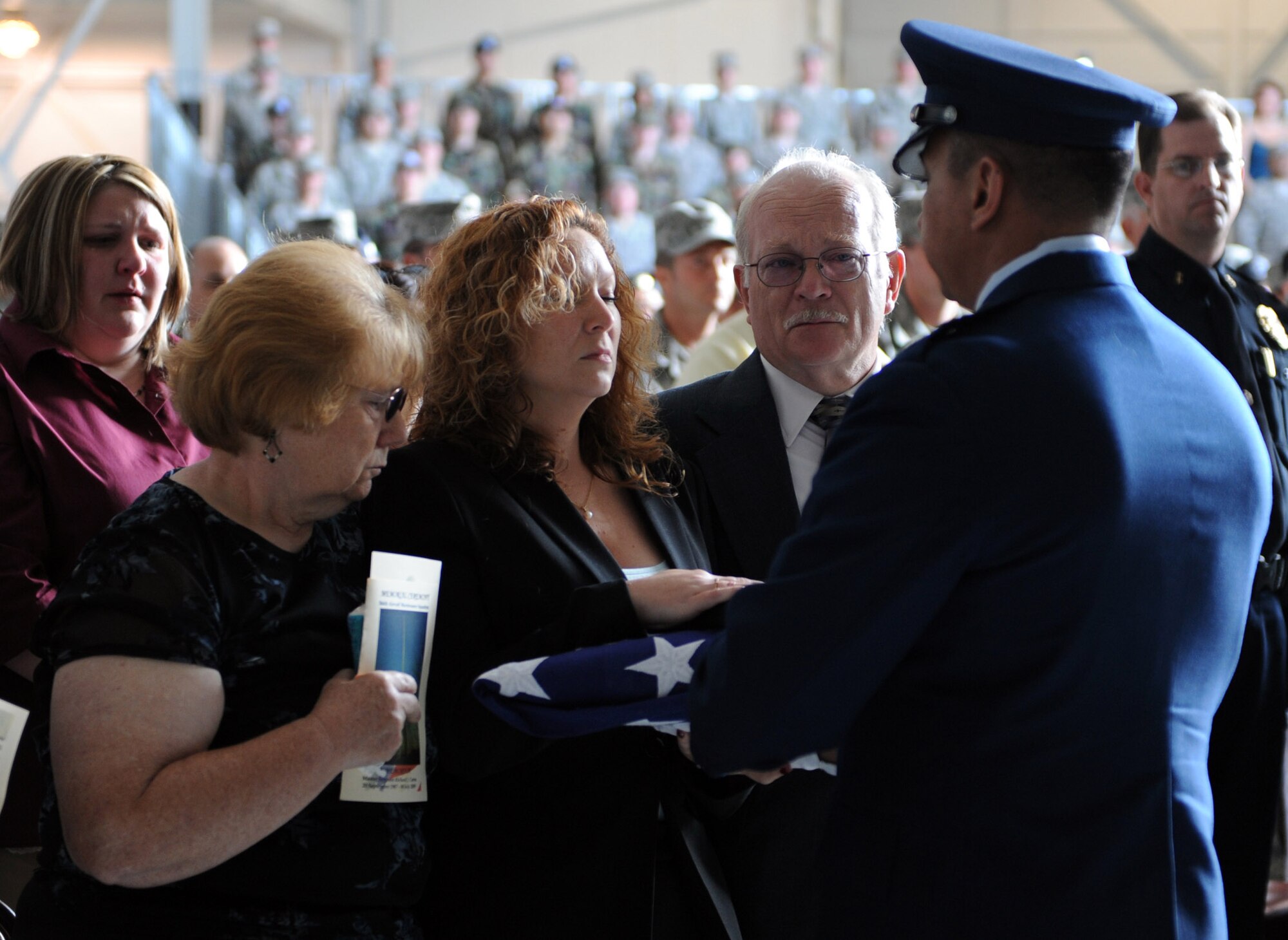 MOUNTAIN HOME AIR FORCE BASE, Idaho - Lt. Col. Luis Gallegos, 366th Aircraft Maintenance Squadron commander, presents Tina Caron, wife of Master Sgt. Richard Caron, with a United States flag during a memorial ceremony at Hangar 1331 July 9. Sergeant Caron was with the 366th Aircraft Maintenance Squadron and passed away in Mountain Home July 4. (U.S. Air Force photo/Airman 1st Class Deborah Lockhart)