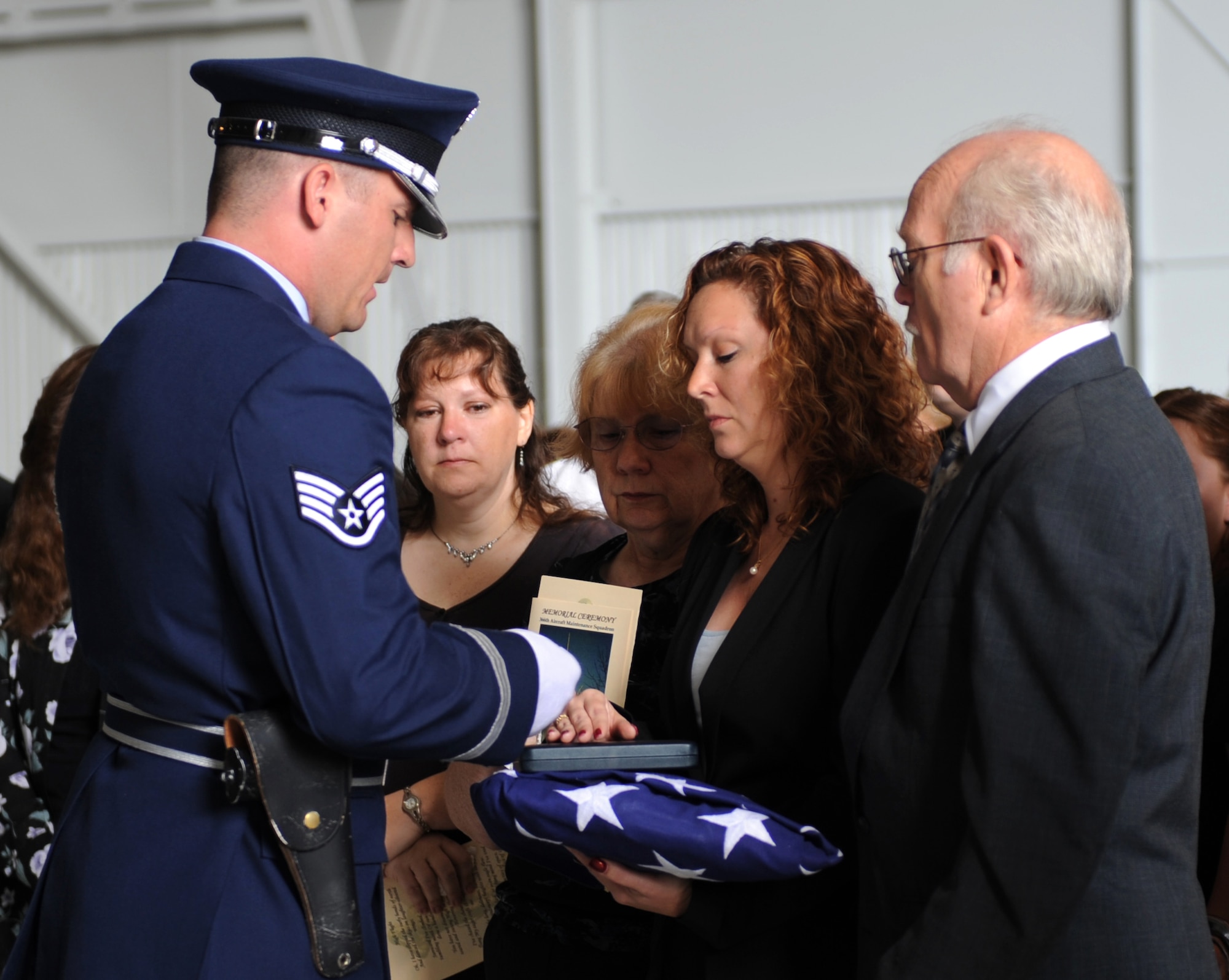 MOUNTAIN HOME AIR FORCE BASE, Idaho – Staff Sgt. Chad Curtis, Mountain Home Air Force Base Honor Guard, presents Tina Caron, wife of Master Sgt. Richard Caron, with the rounds from the seven-man firing party during a memorial ceremony at Hangar 1331 July 9. Sergeant Caron was with the 366th Aircraft Maintenance Squadron and passed away in Mountain Home July 4. (U.S. Air Force photo/Airman 1st Class Renishia Richardson)