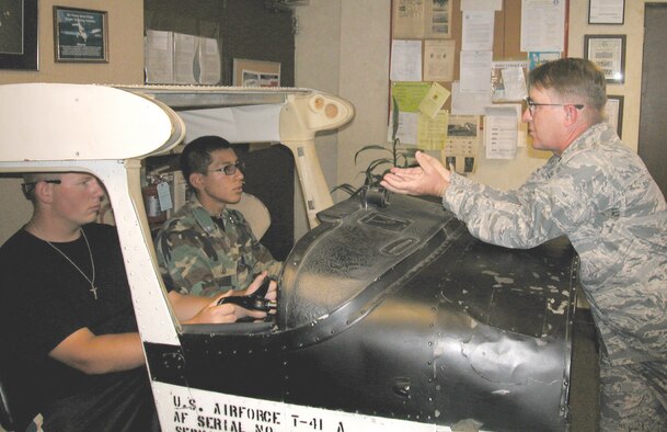 CLASSROOM WISH LIST: “If this was your classroom desk, would you ever be late to class?” Lt. Col. Kelly McPeters asks students as they rotate through the practice cockpit inside the Aero Club office. (U.S. Air Force photo by Megan Just)