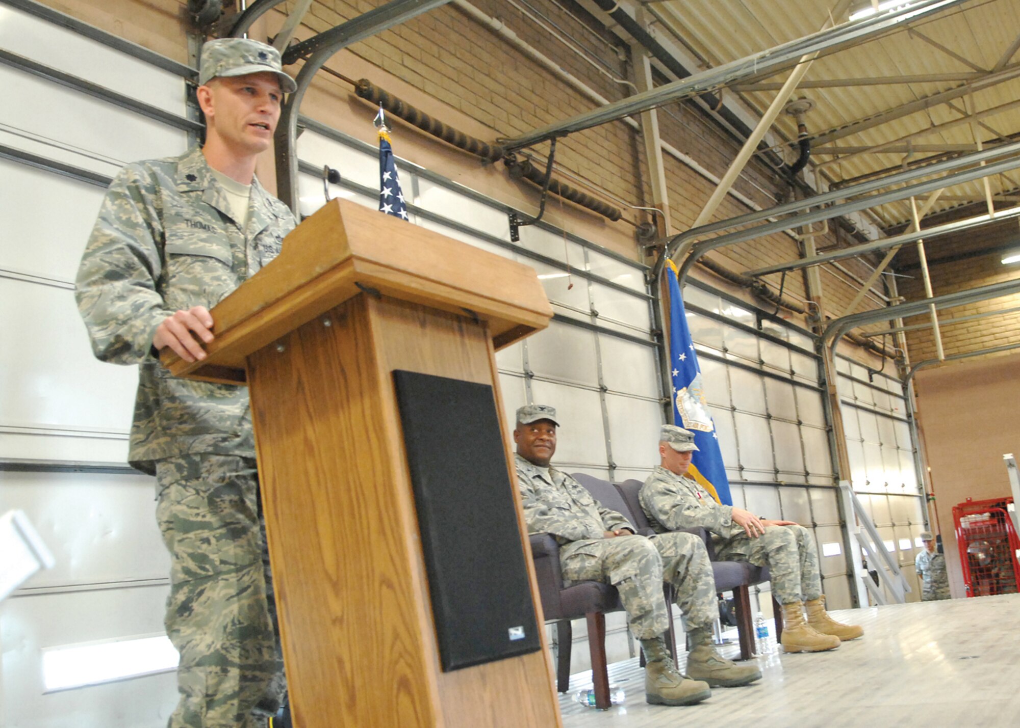 Lt. Col. John Thomas, the new commander of the 56th Civil Engineer Squadron, addresses the crowd during the 56th CES change-of-command ceremony July 2 while Col. Andre Curry, 56th Mission Support Group commander, and Lt. Col. Anthony Ramage, out-going CES commander, look on.(U.S. Air Force photo/ Tech. Sgt. Jeffrey Wolfe)