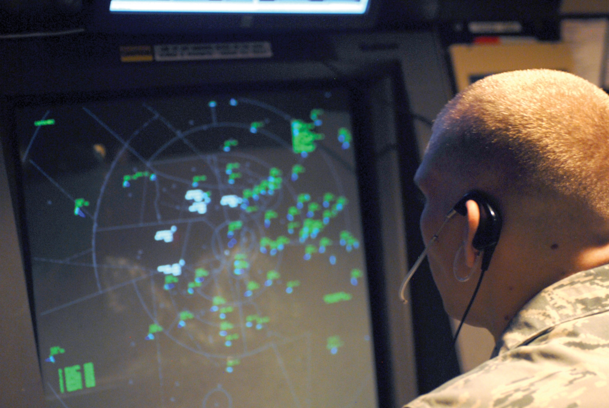 Airman 1st Class Benjamin Shrewsberry, 56th Operations Support Squadron, watches the moving radar screen showing planes flying over Luke and advising them of others flying nearby.(U.S. Air Force photo/ Airman 1st Class Sandra Welch)