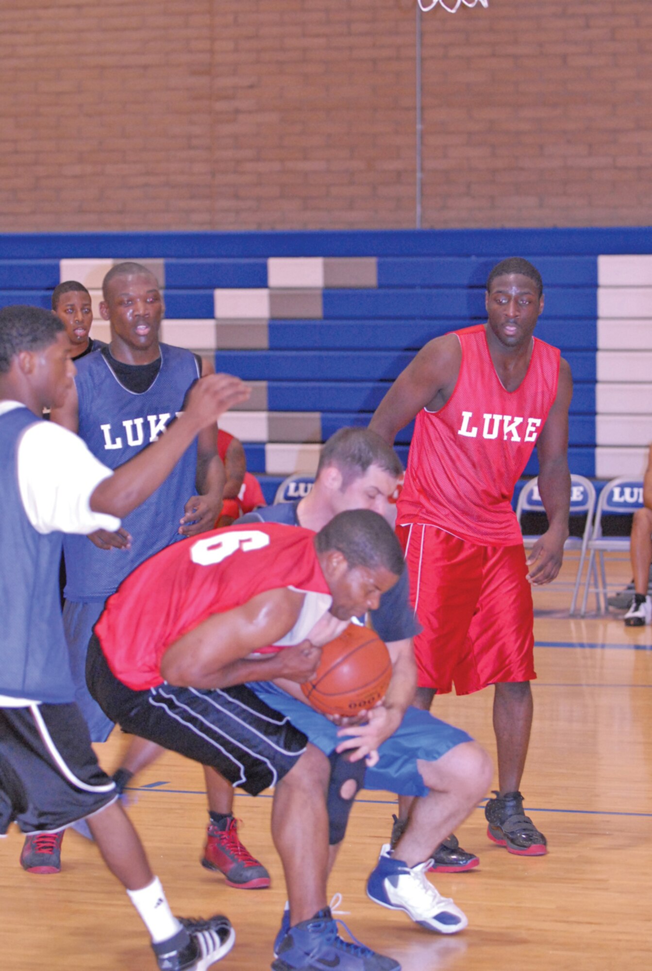 Steven Szymanski, (blue) 56th Logistics Readiness Squadron Team 1 and Albert Banks, 56th Aircraft Maintenance Squadron, fight for a loose ball June 30 in game one of the intramural basketball championship at the Luke Fitness Center. The AMXS took game one but the LRS won game two 53-48 taking the championship. (U.S. Air Force photo/ 2nd Lt. Ryan DeCamp)