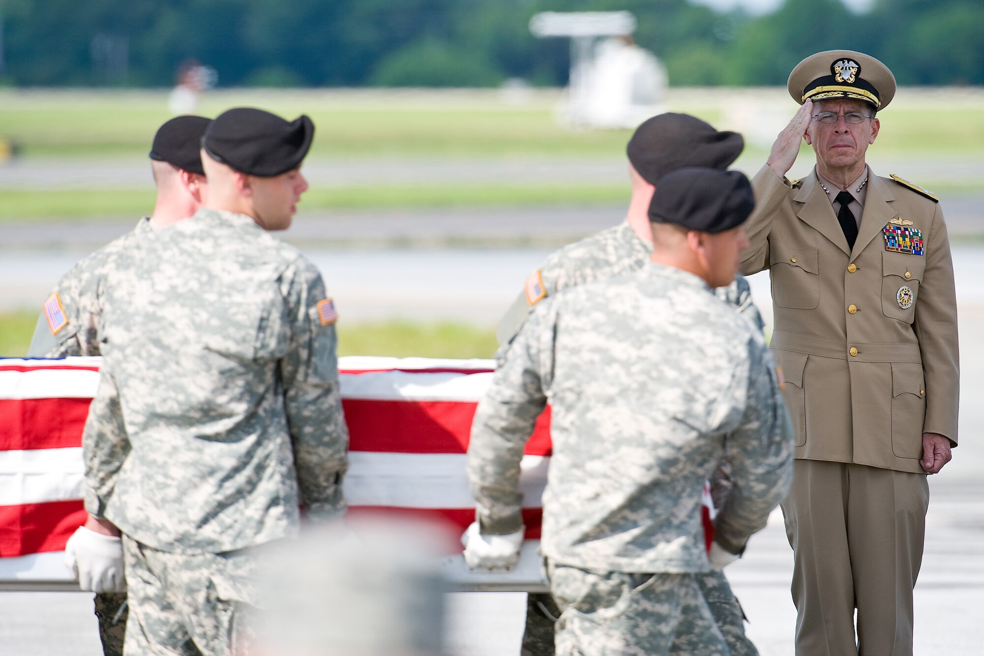Navy Adm. Mike Mullen, chairman of the Joint Chiefs of Staff, renders honors as a U.S. Army carry team transfers the remains of Sgt. Brock H. Chavers at Dover AFB July 8. Sergeant Brock is assigned to Company D, 2nd Battalion, 121st Infantry, Americas, Ga., Georgia Army National Guard. (U.S. Air Force photo/Roland Balik)