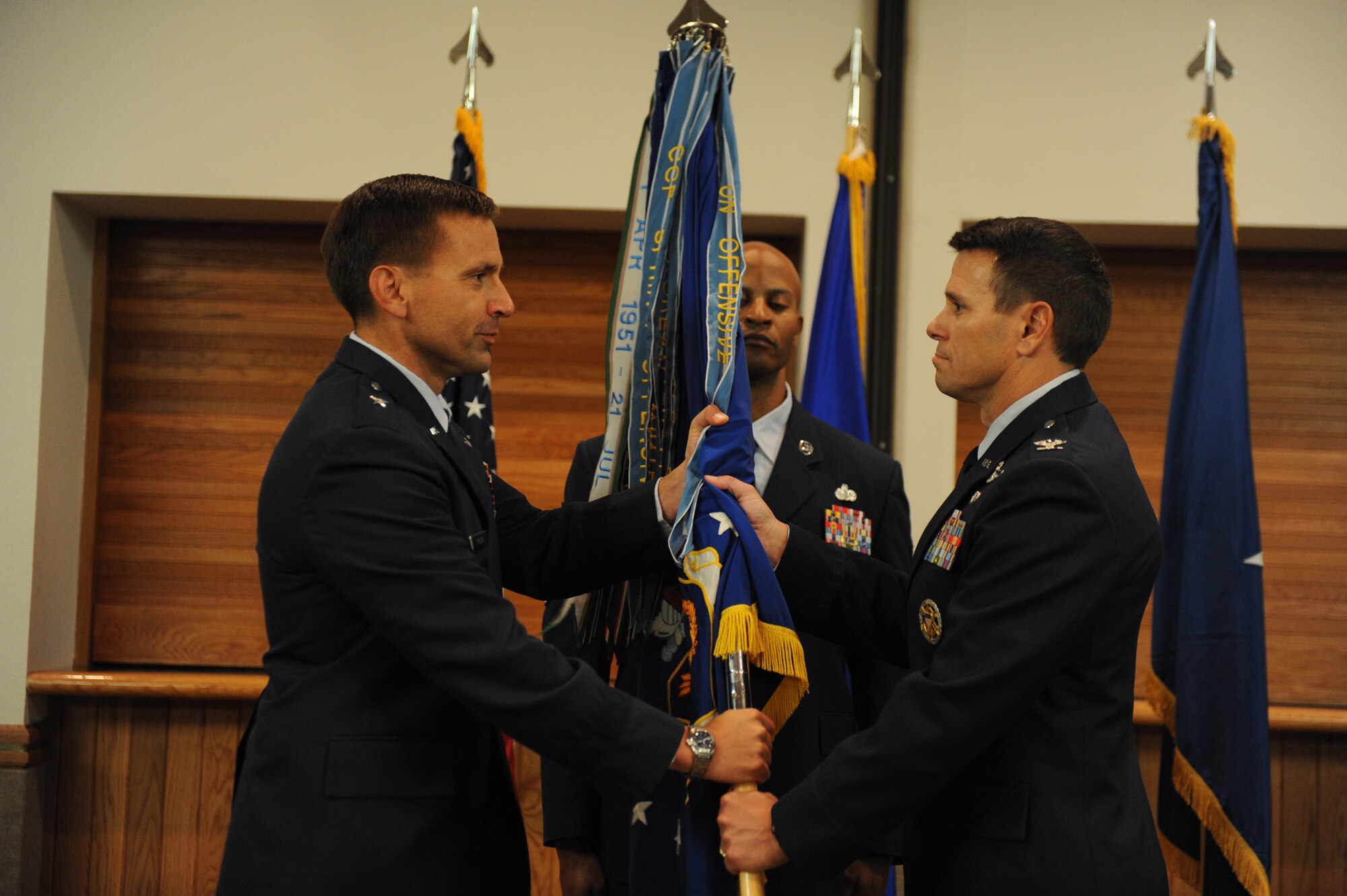 Col. John Montgomery recieves the 98th Range Wing guidon from Brig. Gen. Ted Kresge, United States Air Force Warfare Center commander, during a change-of-command ceremony at the Nellis Officer?s Club July 7. The 98th RANW provides command and control of the Nevada Test and Training Range.(U.S. Air Force photo by/Senior Airman Nadine Y. Barclay/RELEASED)