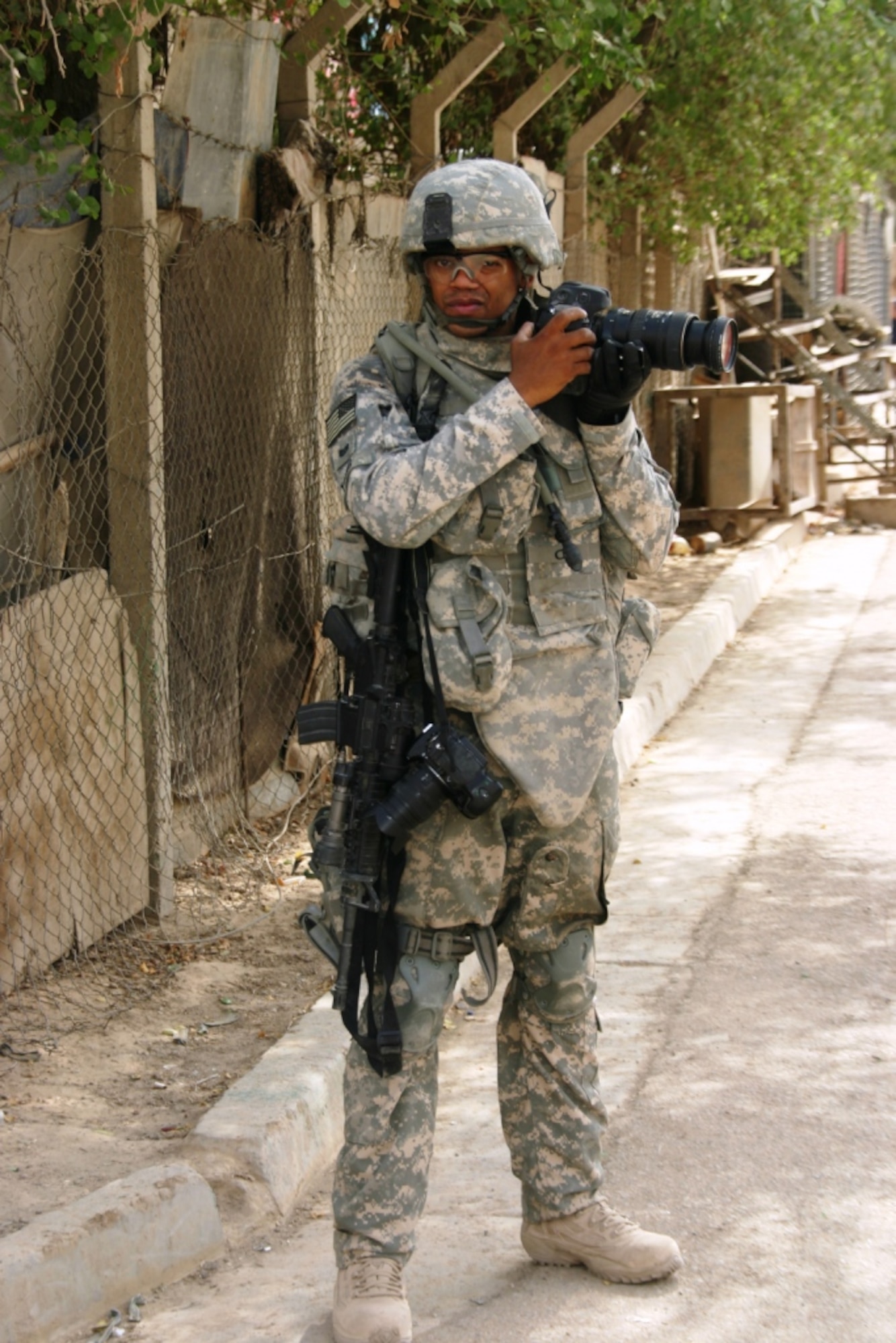 BAGHDAD, Iraq -- Tech. Sgt. Cohen, an Air Force photojournalist, takes pictures on a dismounted patrol in 2008 during his six-month deployment to Iraq. During the deployment, Sergeant Young was ranked No. 1 of 40 combat cameramen, capturing historical moments in the country's storied history. He also logged more than 400 hours "outside the wire" on combat and humanitarian missions. For his actions, he earned a Bronze Star Medal in a ceremony at Hickam Air Force Base, Hawaii, June 29. (Courtesy photo)