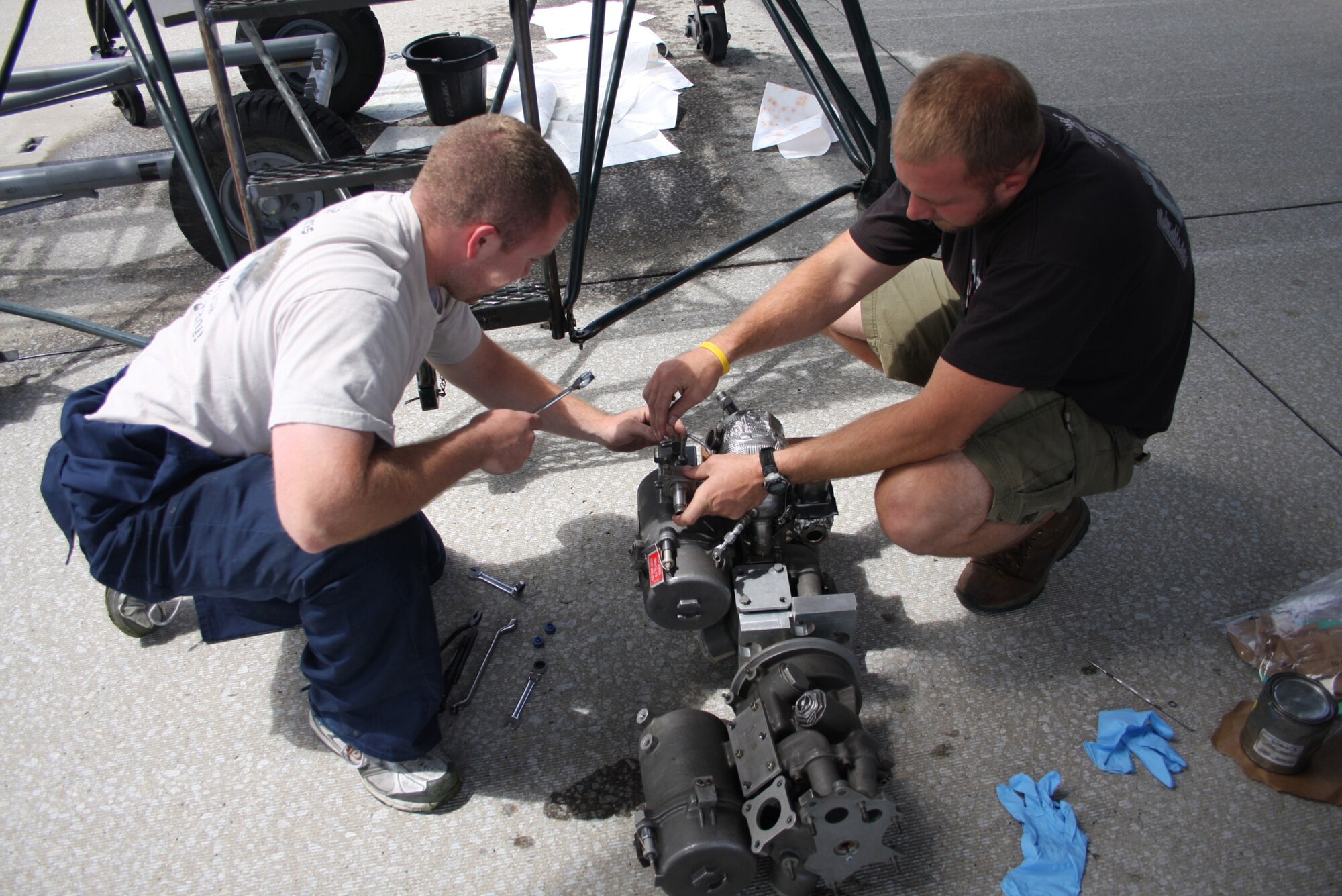 WRIGHT-PATTERSON AIR FORCE BASE, Ohio – Tech. Sgt. Mike Rosato, left, and Staff Sgt. Chris Falloon, Air Reserve Technicians assigned to the 445th Aircraft Maintenance Squadron, take advantage of the sunny weather to make repairs on a fuel pump belonging to a C-5 Galaxy aircraft. (Air Force photo/Senior Airman Mikhail Berlin)