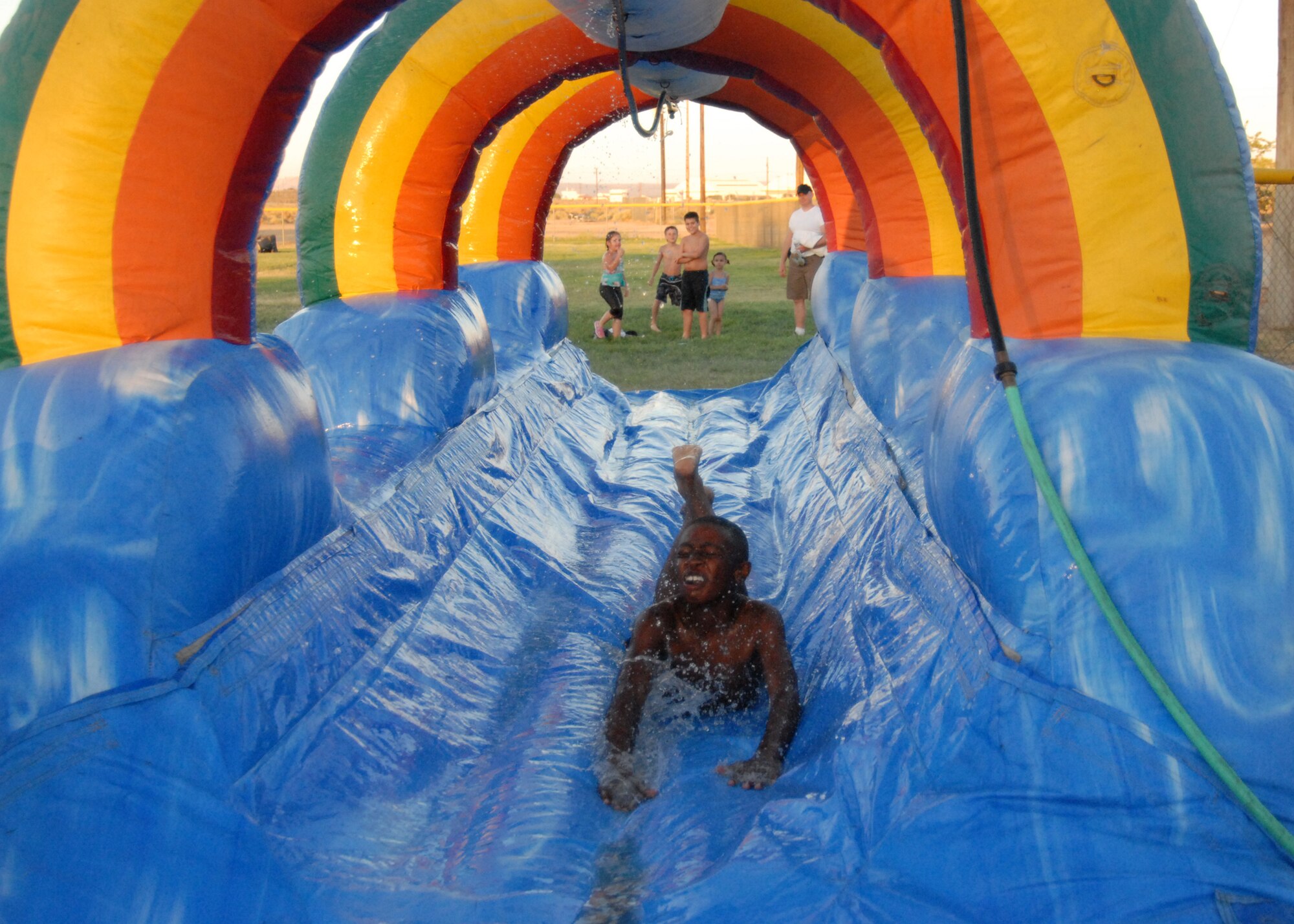 Base resident slides across a slip and slide during the Summer Bash at Robert and Wings Field here July 4. Summer Bash is in celebration of the United States' 233rd birthday with carnival rides, music, food, drinks, games and culminated with a fireworks display. (Air Force photo by Airman 1st Class William O’Brien)