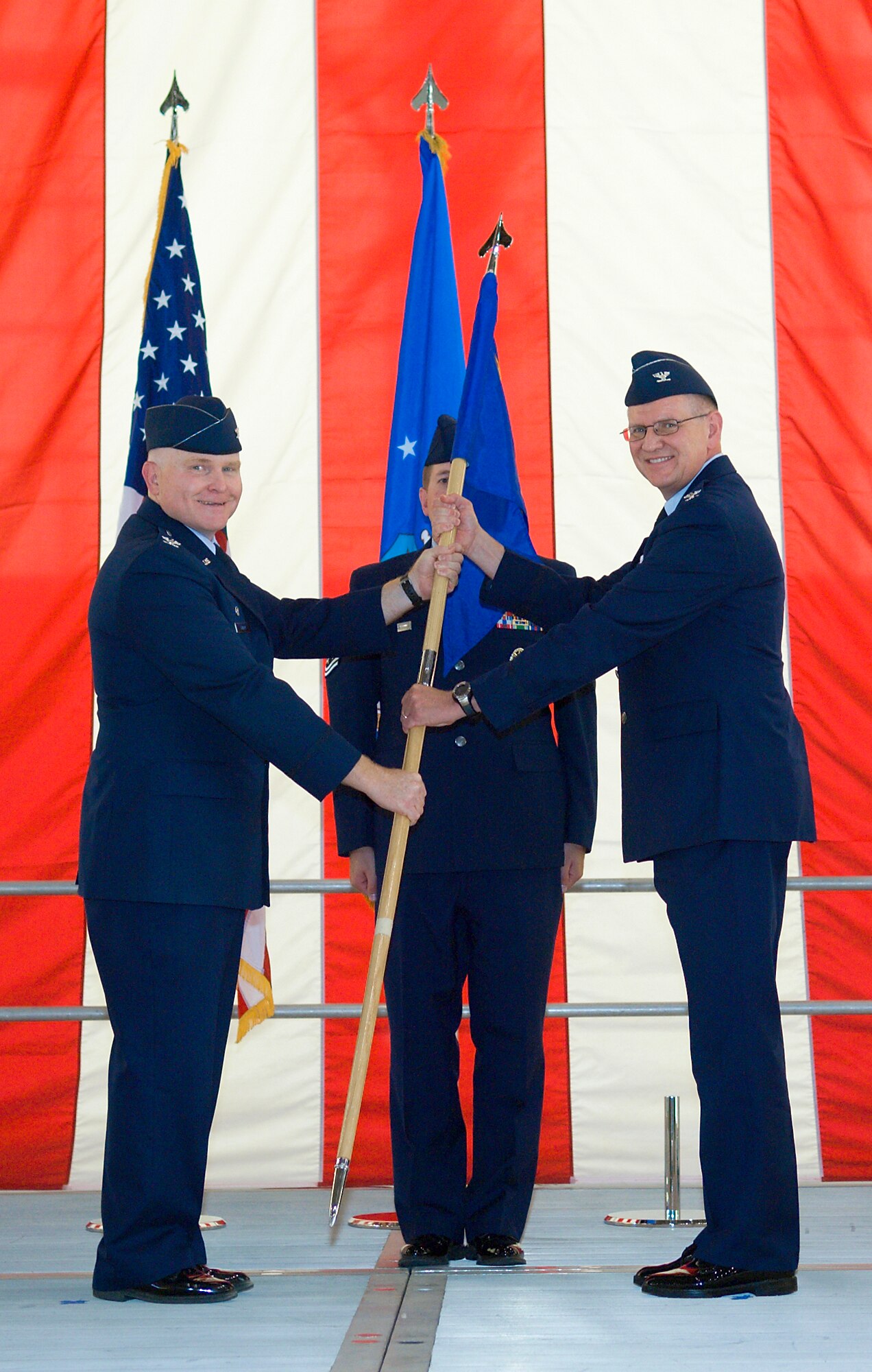Col. Jerry Gandy (left), 95th Air Base Wing commander, passes the 95th Communications Group guidon to Col. Paul R. Hardy during a change of command ceremony in hangar 1600 July 6. (Air Force photo/Mike Cassidy)

