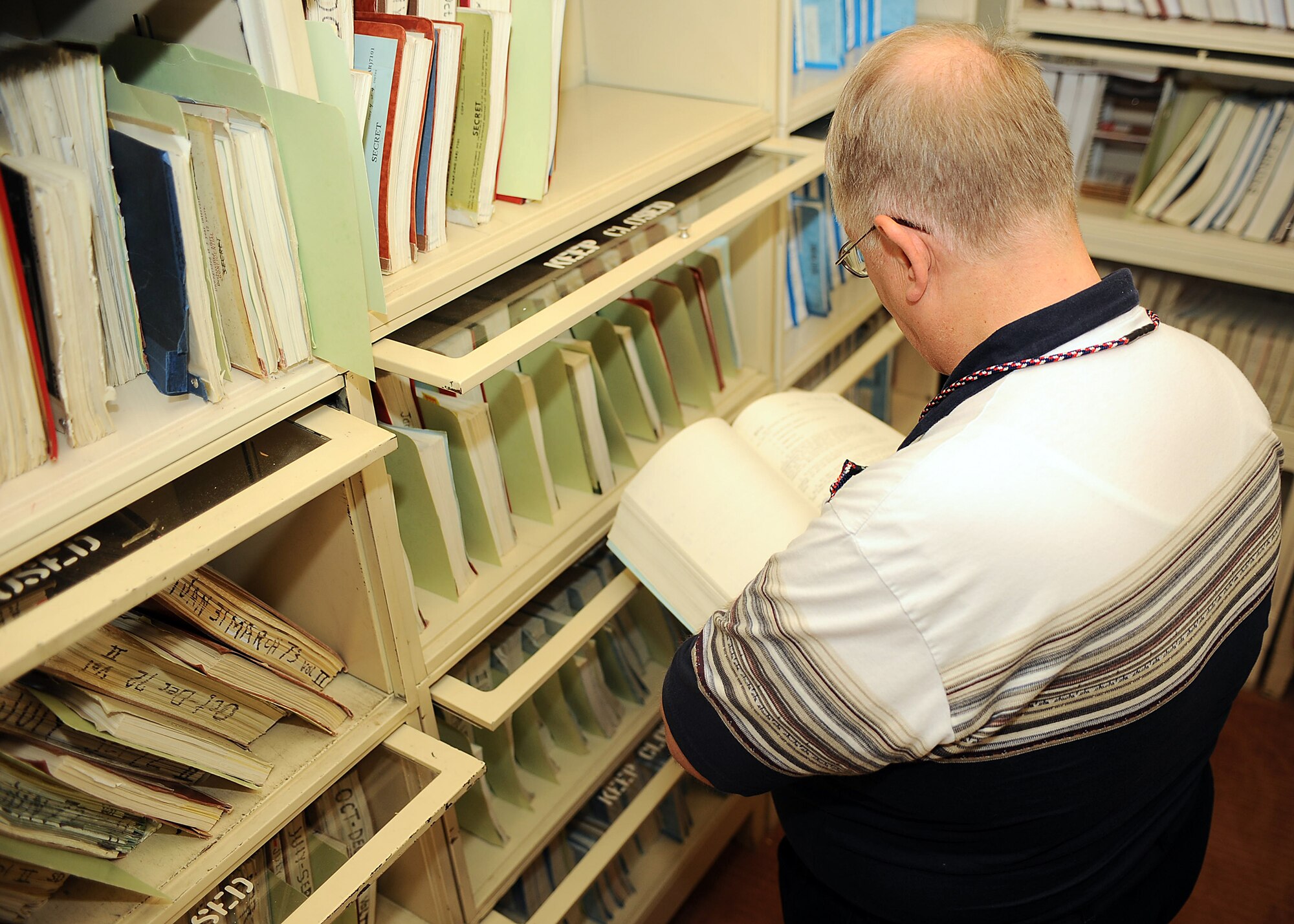 Mr. Ralph Jackson, 49th Fighter Wing Historian, looks over historical documents in the vault of the Wing Historian Office at Holloman Air Force Base, N.M., July 1. (U.S. Air Force photo/ Airman 1st Class DeAndre Curtiss)