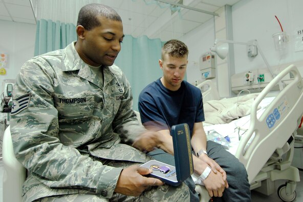 Staff Sgt. Christopher Thompson visits with a patient at the Craig Joint-Theater Hospital at Bagram Air Field, Afghanistan, July 1. Sergeant Thompson, the NCO in charge of hospital chapel operations, is deployed from the U.S. Air Force Academy in Colorado Springs, Colo. (U.S. Air Force photo)
