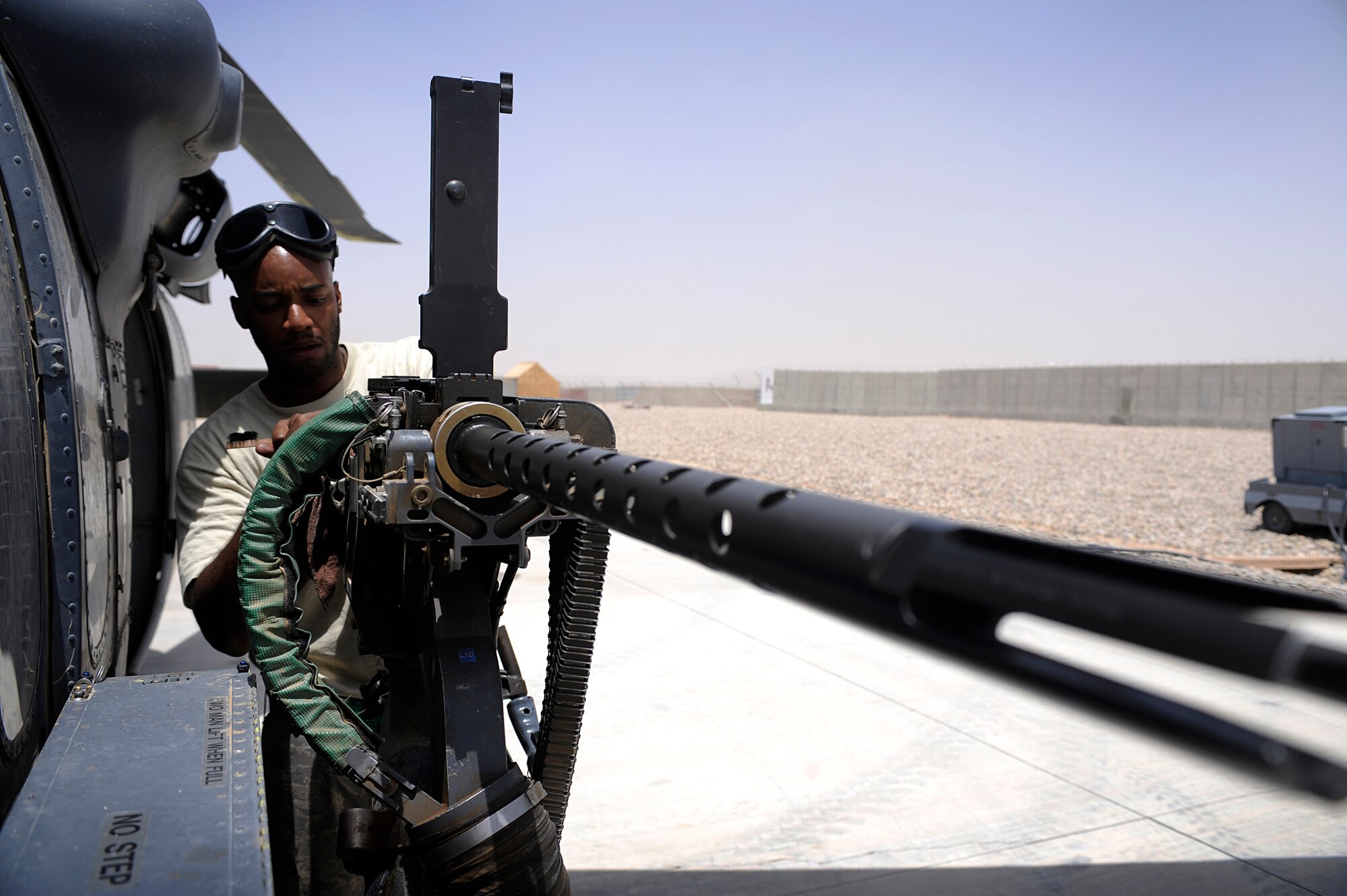 U.S. Air Force Senior Airman LaMarr Richmond, 129th Expeditionary Rescue Squadron maintainer, performs routine maintainence on the .50 caliber machine gun of an HH-60G Pave Hawk, June 24, 2009, Camp Bastion, Afghanistan. (U.S. Air Force Photo by Staff Sgt. Shawn Weismiller)
