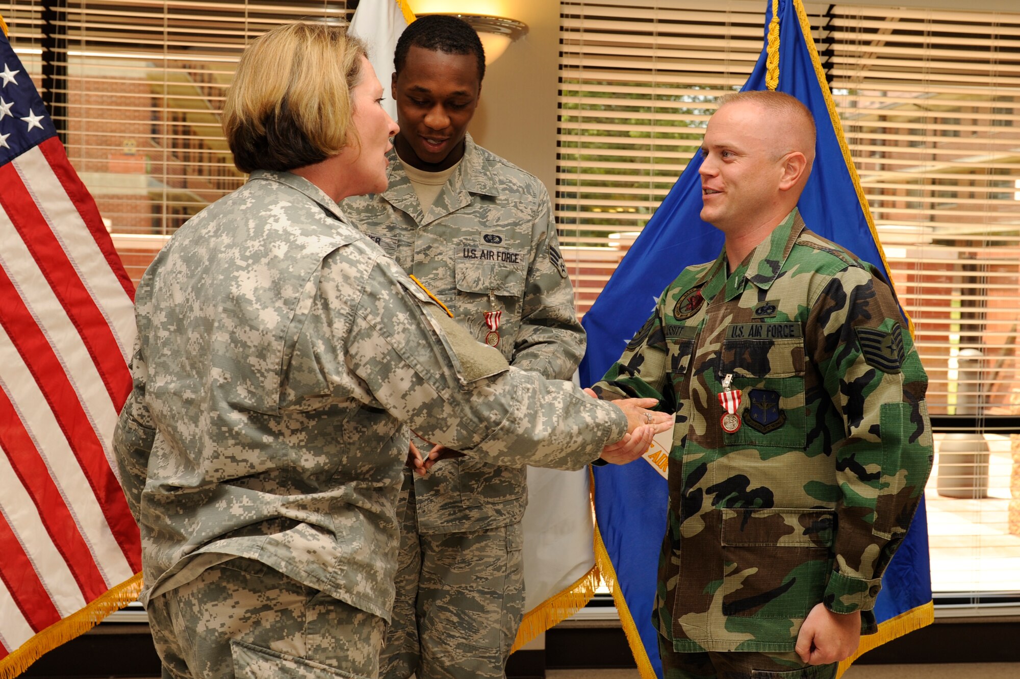 Army Command Sgt. Maj. Debrah Collins of the Arkansas National Guard, congradulates Senior Airman Dennis Gardner and Tech. Sgt. Brandon Issitt of the Little Rock Air Force Base Honor Guard June 30 at the Hercules Dining Facility. (U.S. Air Force photo by Airman Lausanne Pacheco)