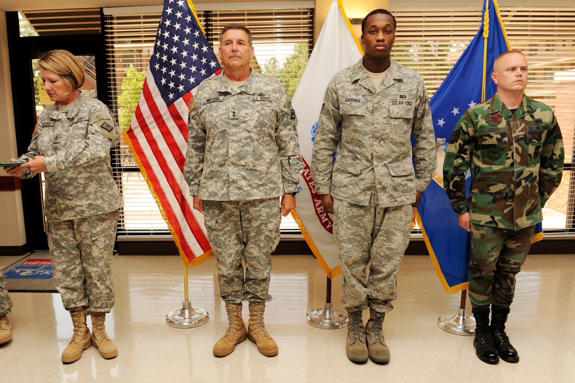 (From left) Army Command Sgt. Maj. Debrah Collins and Army Maj. Gen. William Wofford of the Arkansas National Guard, Senior Airman Dennis Gardner and Tech. Sgt. Brandon Issitt of the Little Rock Air Force Base Honor Guard, stand at attention during the reading of the Arkansas Exceptional Service Medal citation at the Hercules Dining Facility on base June 30, 2009. (U.S. Air Force photo by Airman Lausanne Pacheco)