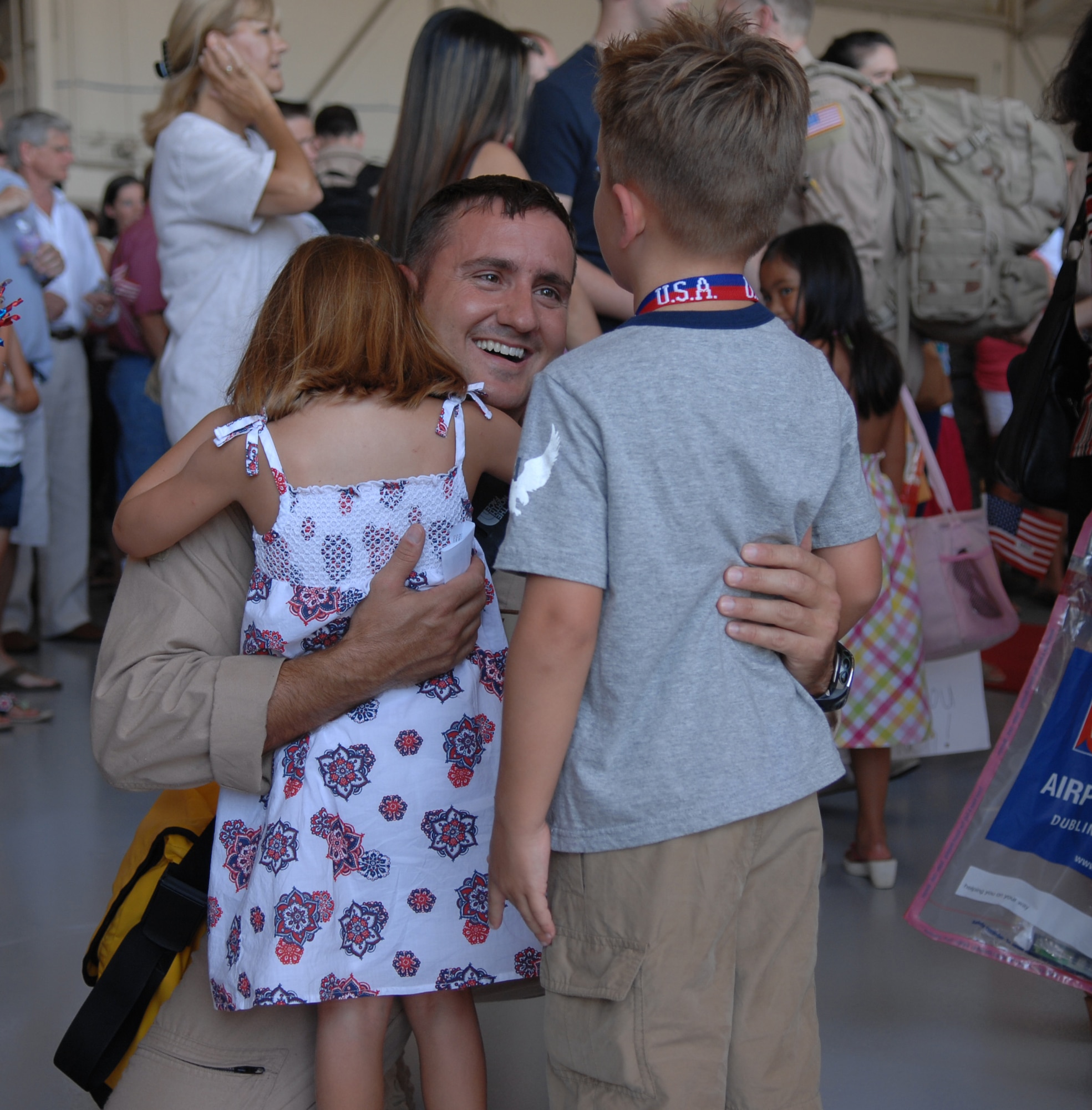 HURLBURT FIELD, Fla.-- Captain Brad Roundtree enthusiastically greets his children Iris (left) and Layk upon returning to Hurlburt Field from his deployment to Southeast Asia July 4. 166 men and women returned to Hurlburt Field in a mid-morning ceremony (U.S. Air Force photo/Technical Sergeant Scott Mackay).
